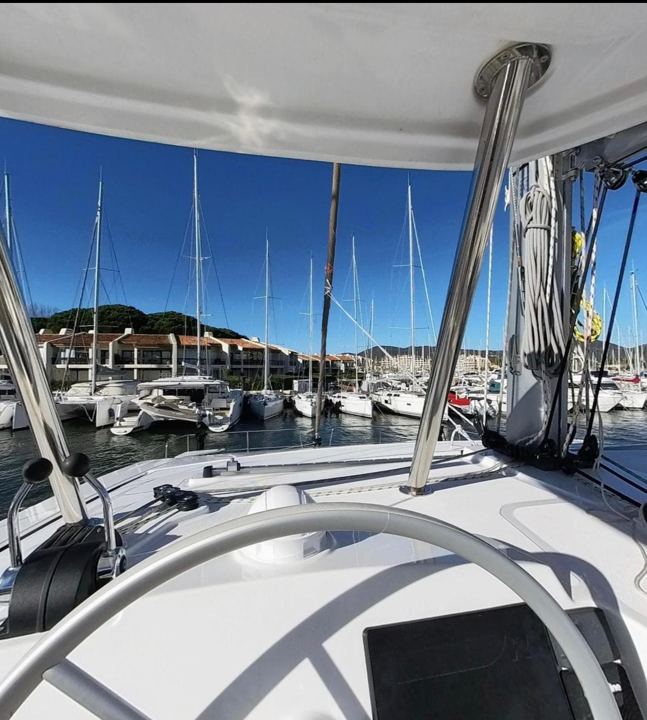 Modern Bali 4.4 yacht docked at marina, clear blue sky, 2023 model.