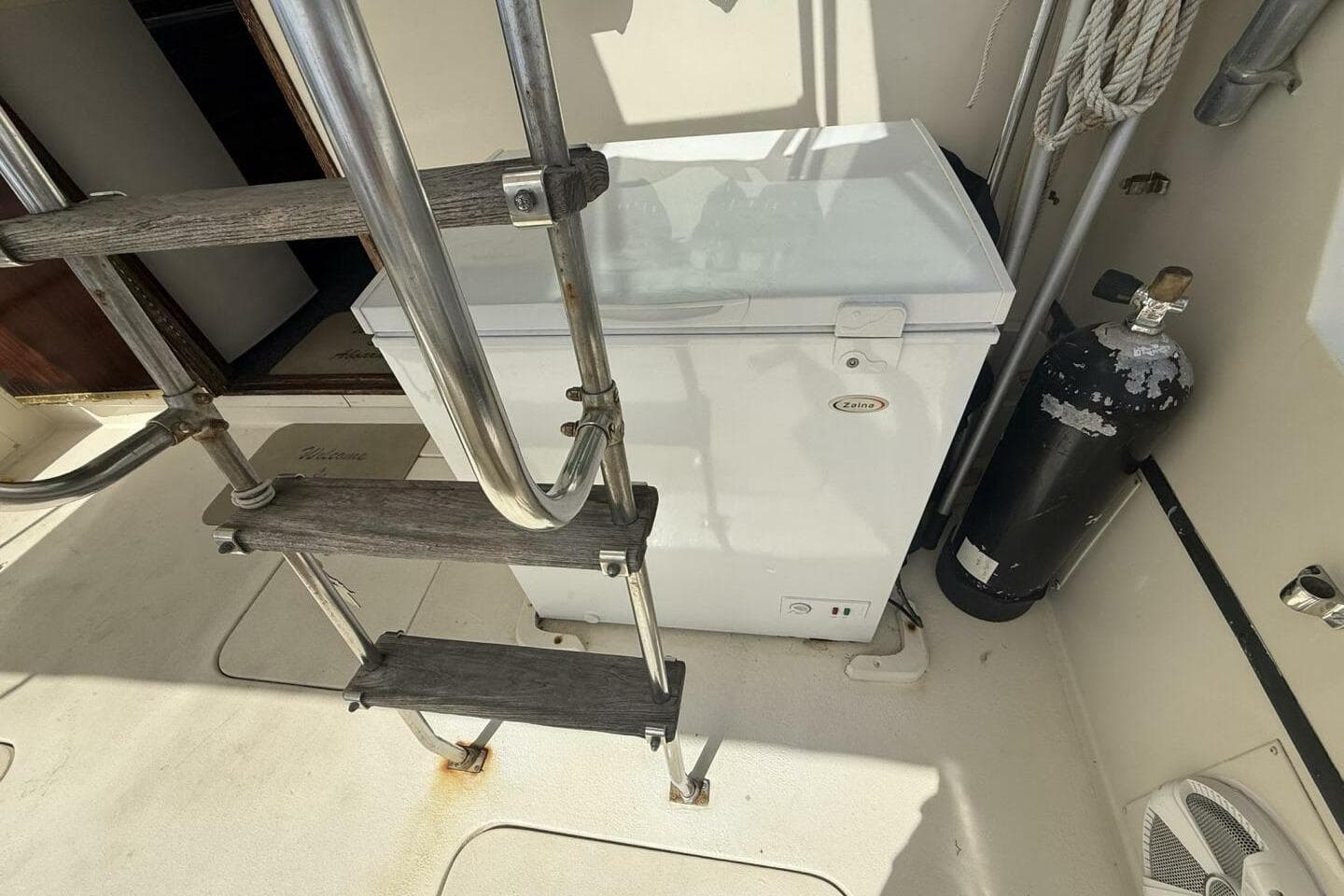 1979 Hatteras 37 Convertible boat deck with ladder, freezer, and scuba tank.