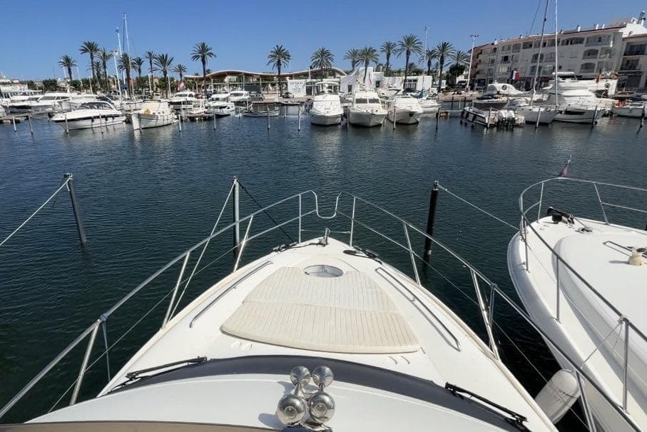 Bow view of a 2000 Princess 38 yacht docked in a marina with palm trees.