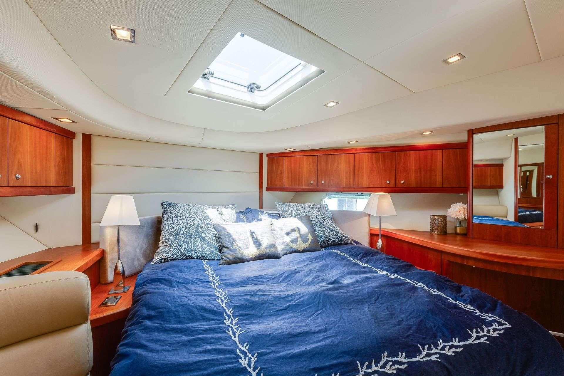Luxurious bedroom interior of 2009 Sunseeker Manhattan 70 yacht with elegant wood finishes.
