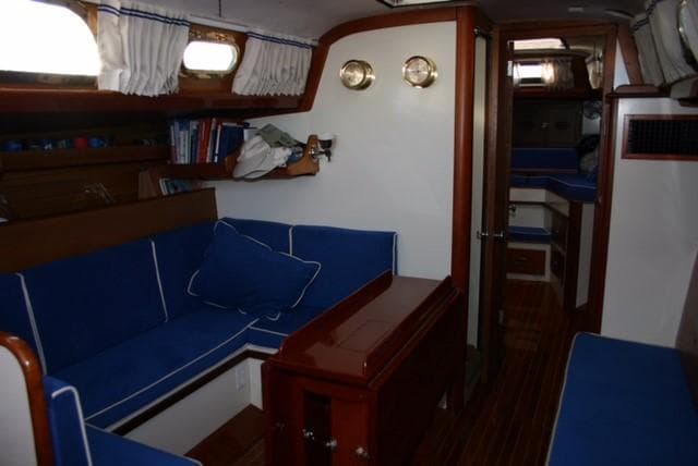 Interior of a 1967 Hinckley Bermuda 40 sailboat with blue seating and wooden accents.