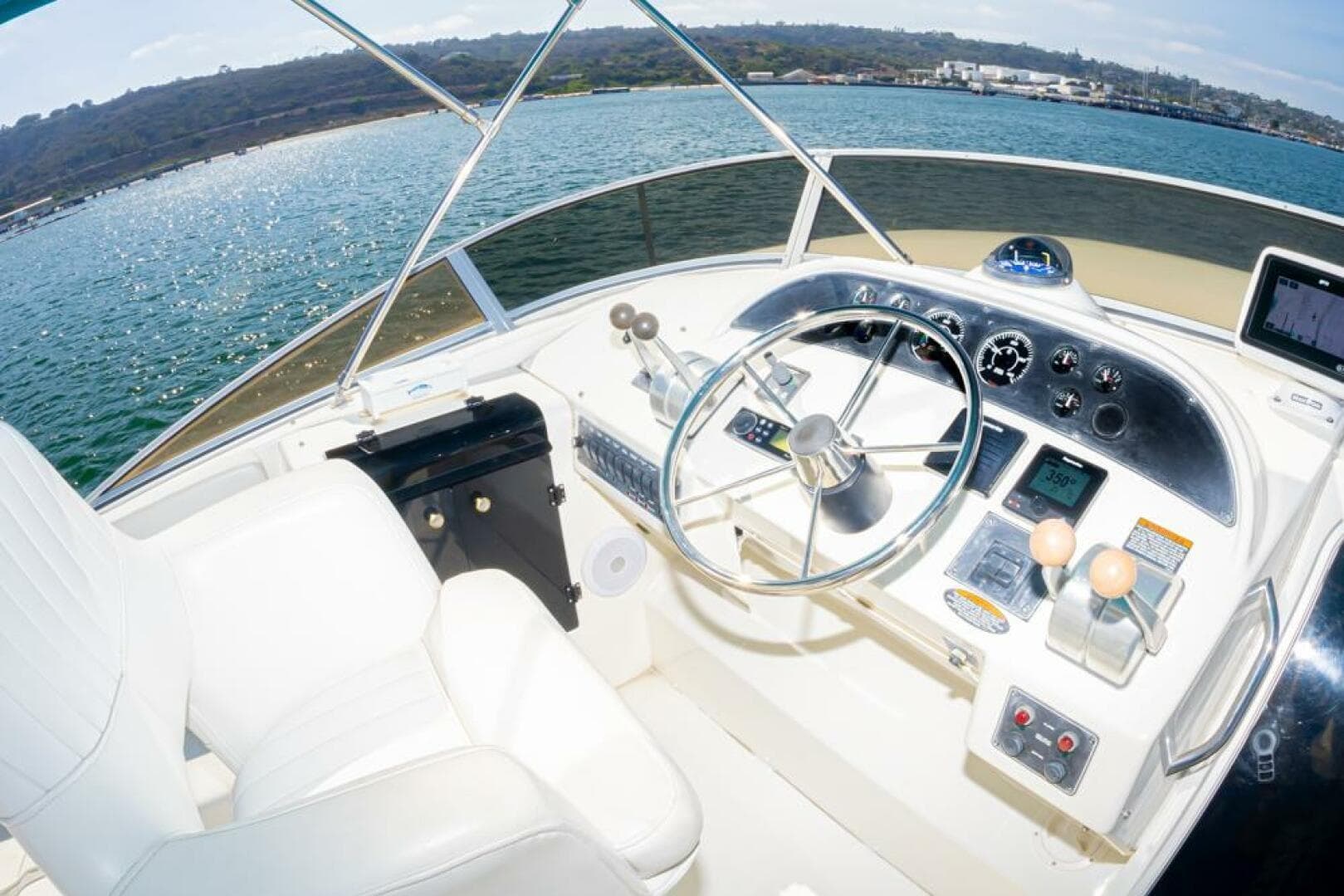 Pilothouse of 2004 Meridian 490 yacht with steering wheel and control panel.