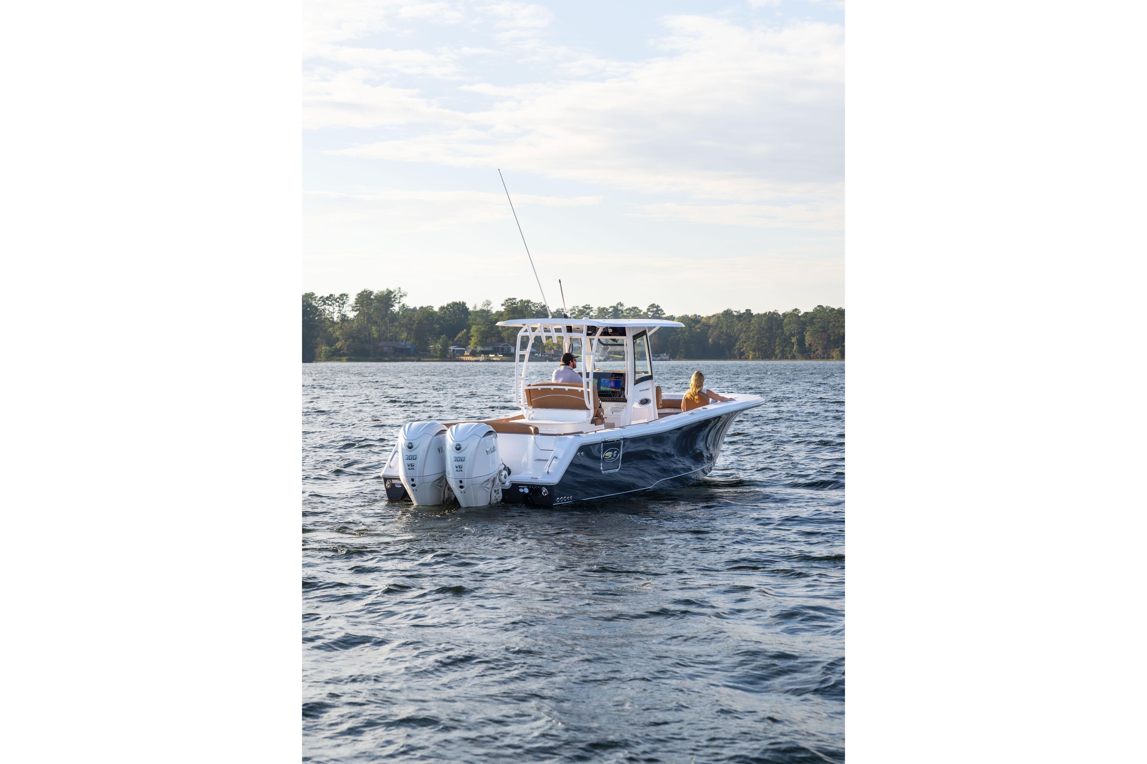 2026 Sea Hunt Ultra 285 SE boat cruising on a serene lake.