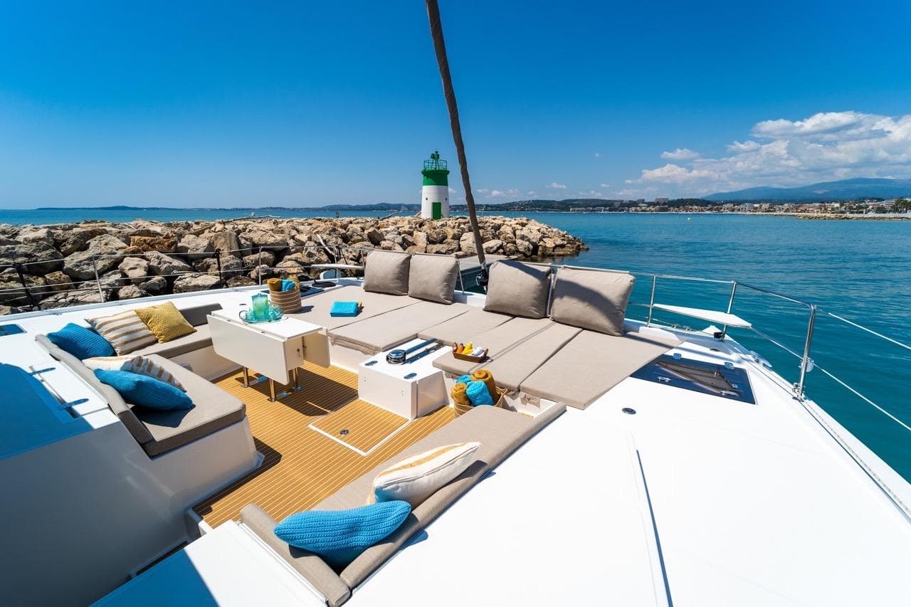 Luxurious Bali 5.4 yacht deck with seating, ocean view, and lighthouse, 2022 model.