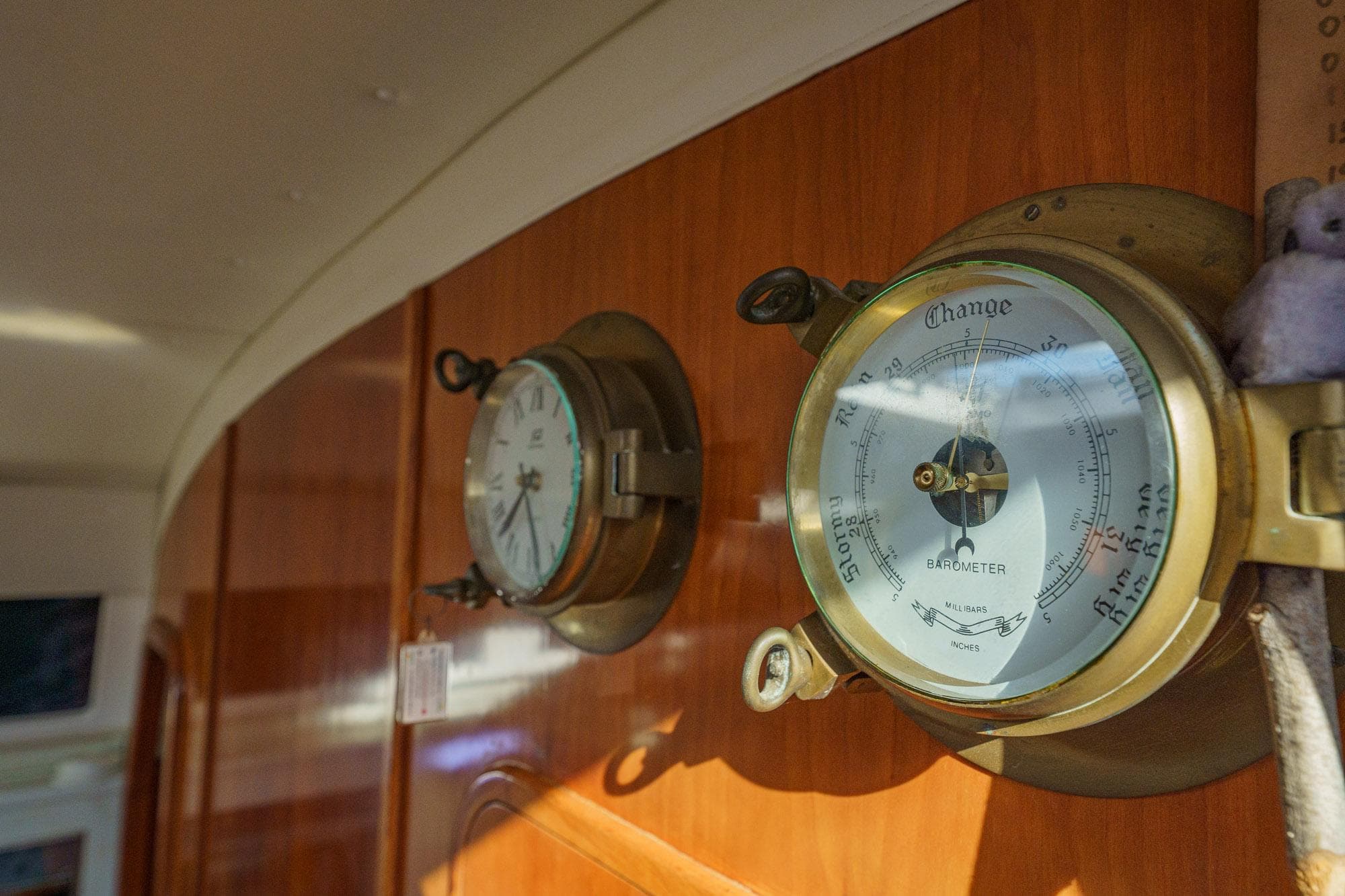 Barometer and clock on wooden panel inside 1995 Prout 45 yacht.
