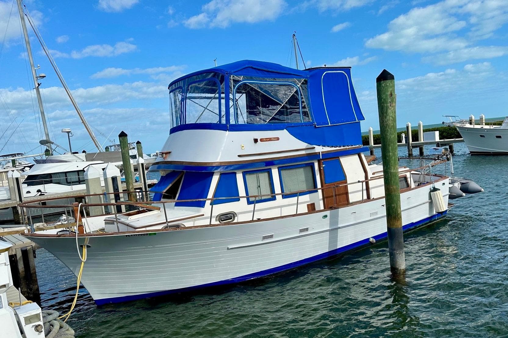 1981 Albin 36 Trawler docked at marina under blue sky.