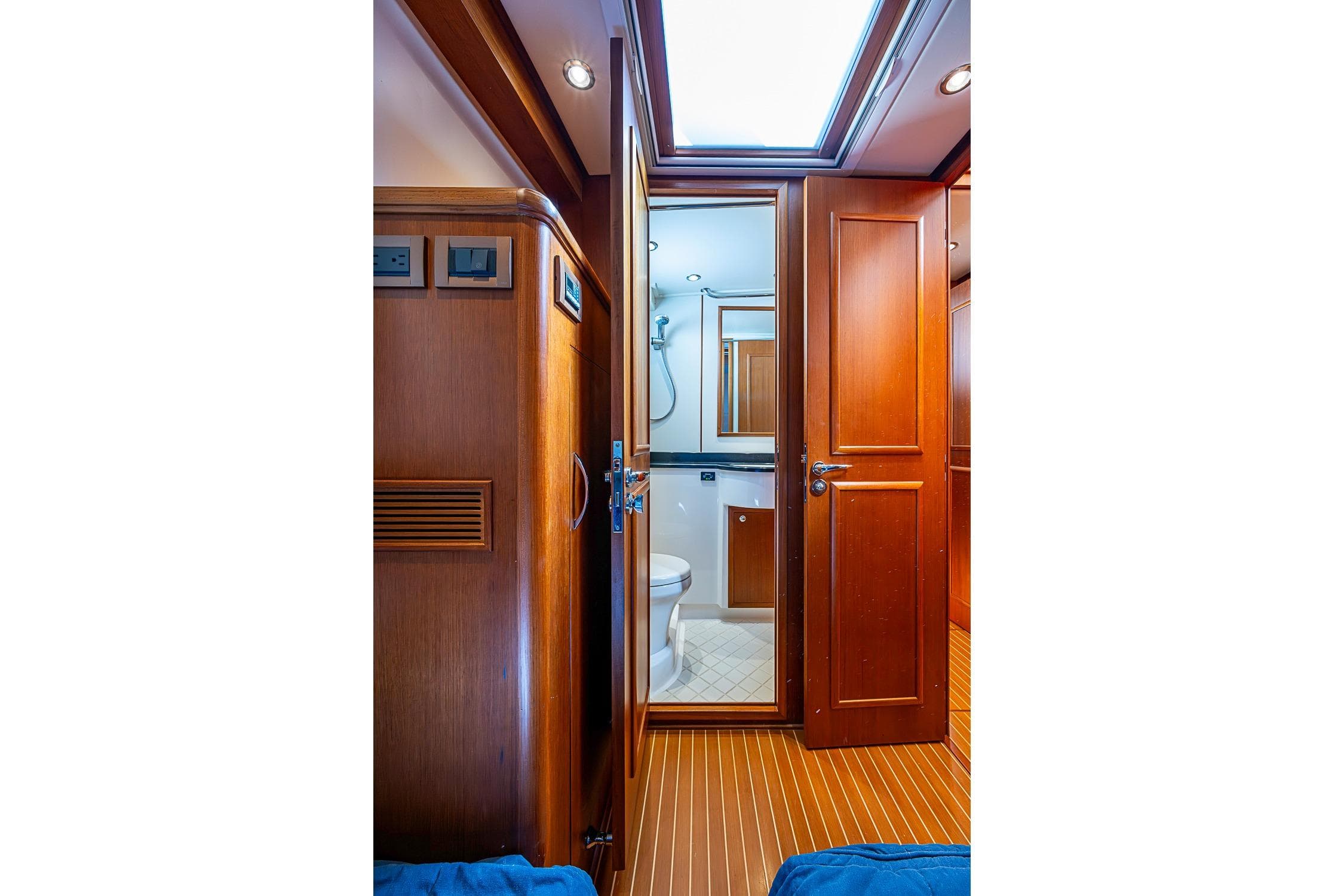 Interior of 2013 Grand Banks 43 Europa yacht, featuring wooden cabinetry and a compact bathroom.