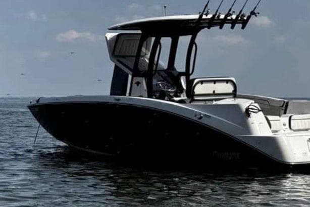2022 Yamaha 255 FSH boat on calm water, featuring sleek design and fishing rod holders.