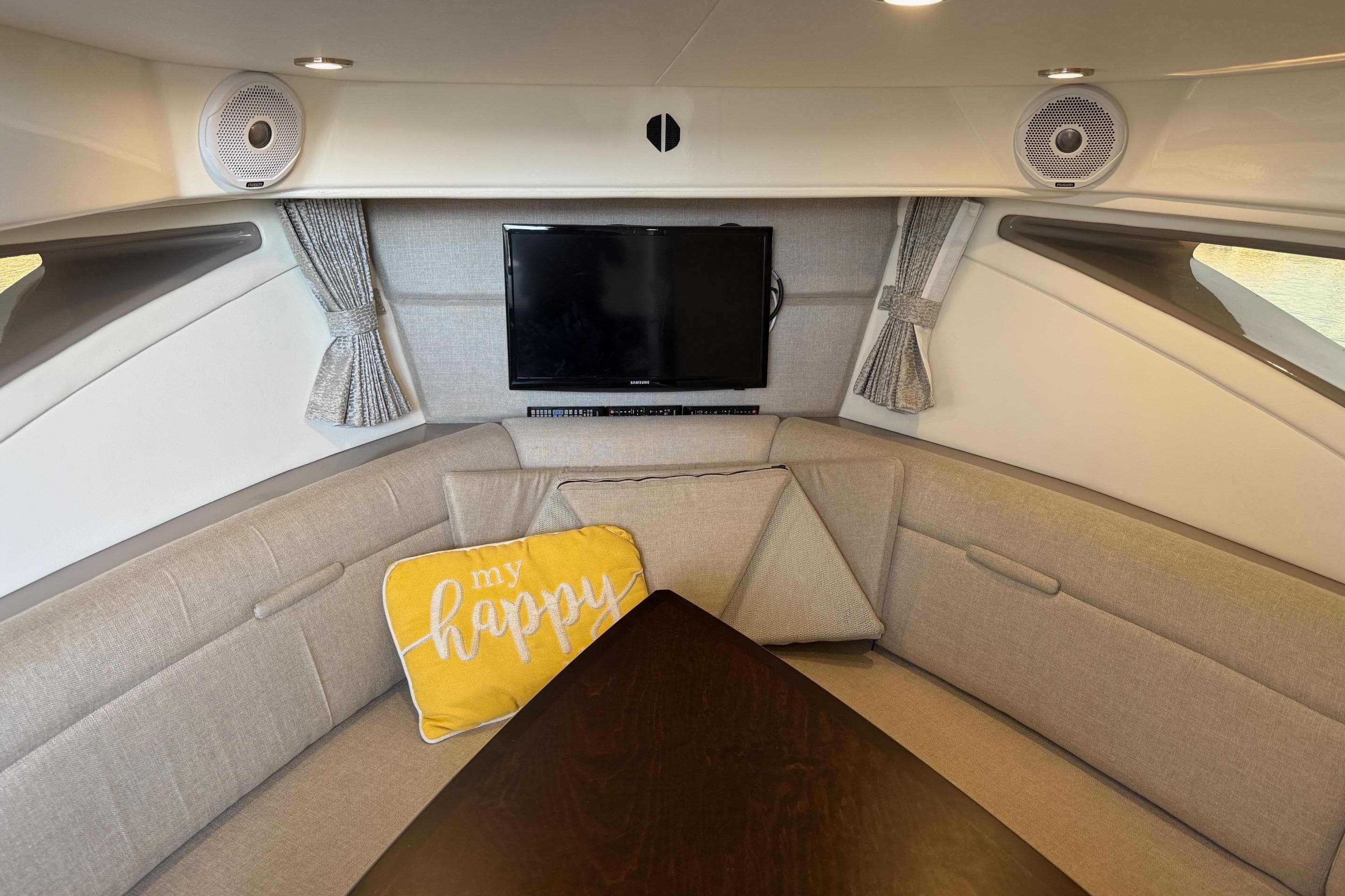 Interior of 2019 Sea Ray Sundancer 320 with cozy seating and TV.