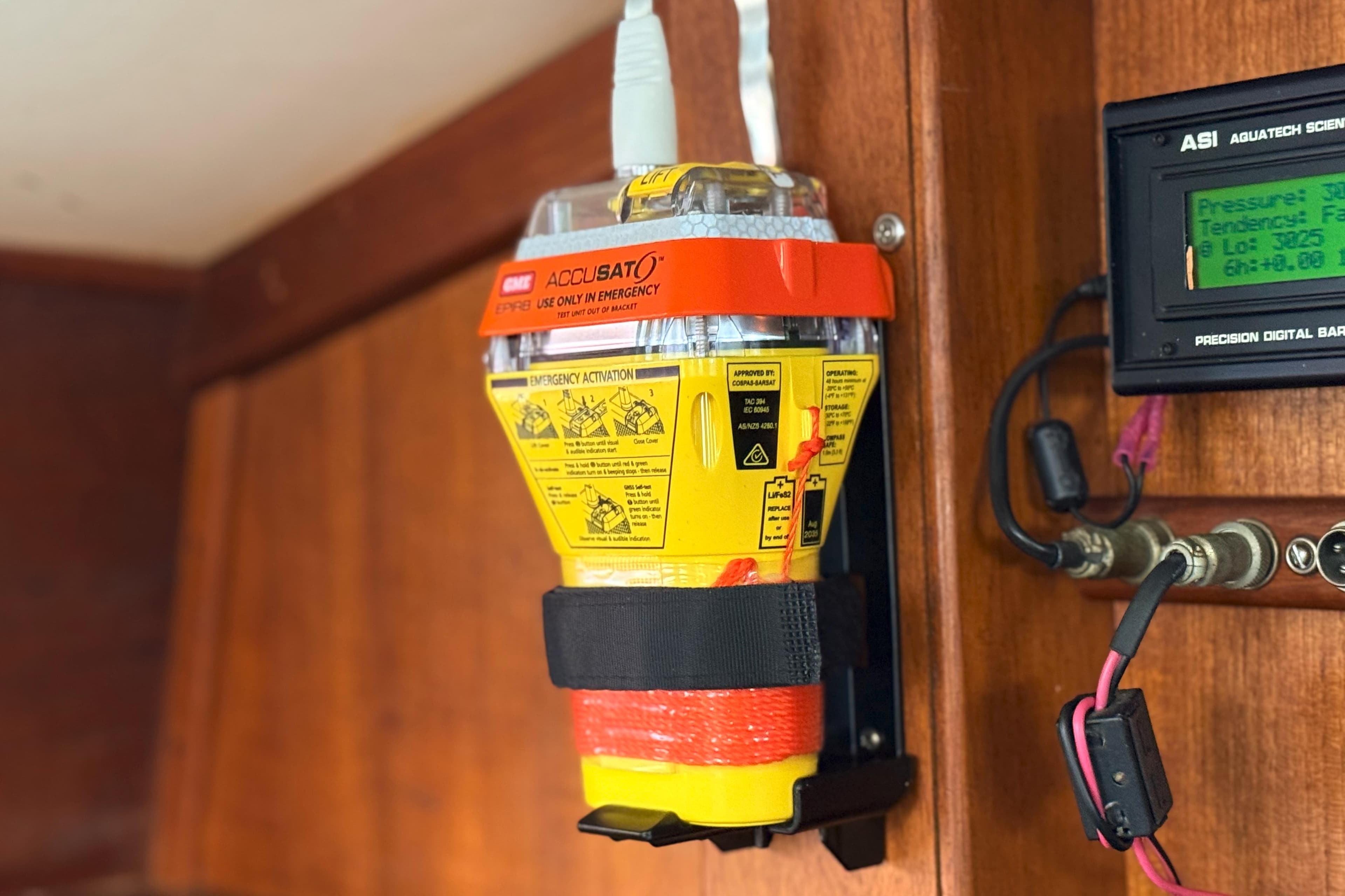 Emergency beacon on 1974 Islander 34 boat, mounted beside digital barometer.