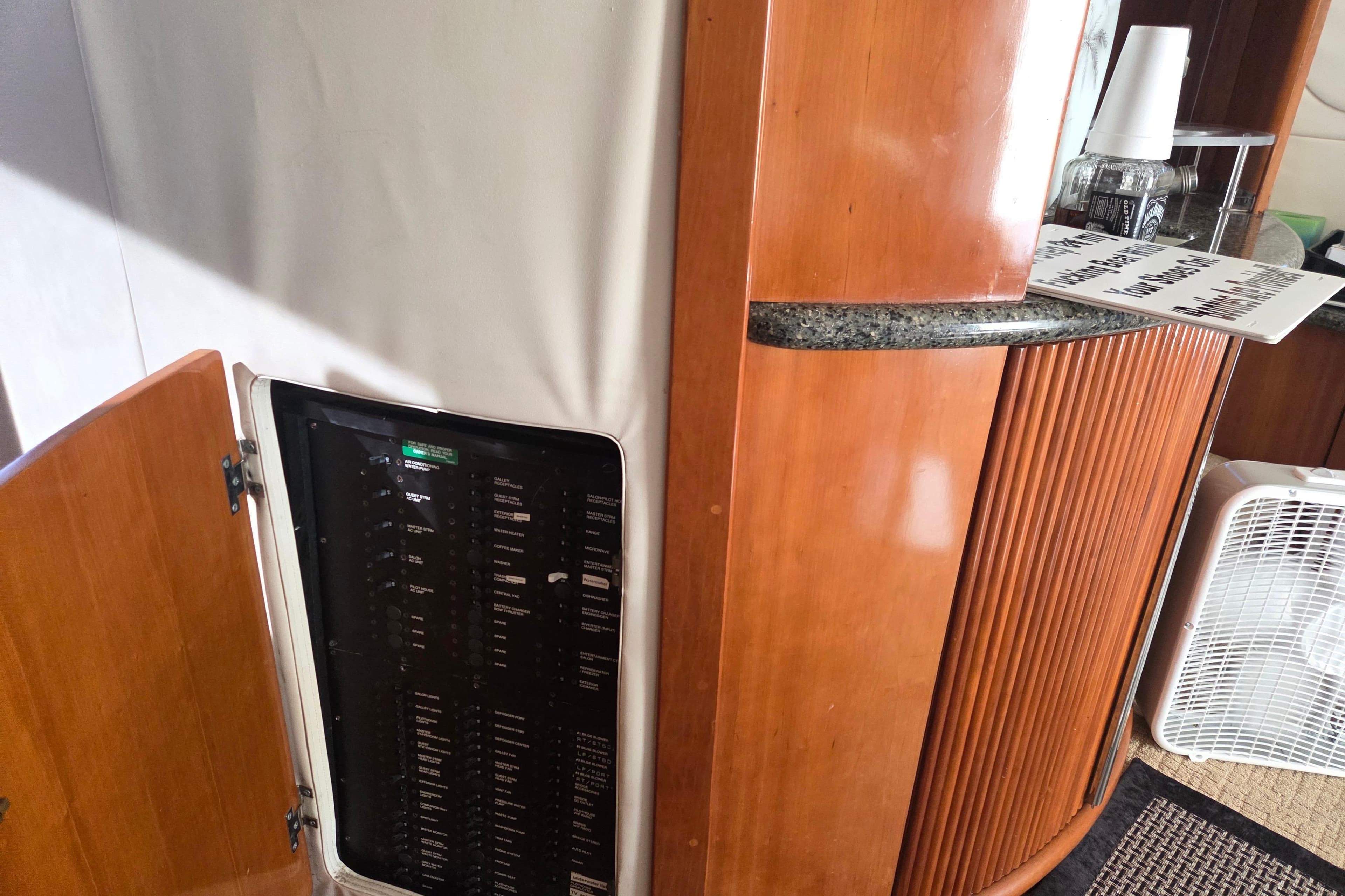 Interior of 2000 Carver 450 Voyager Pilothouse with open electrical panel and wooden cabinetry.