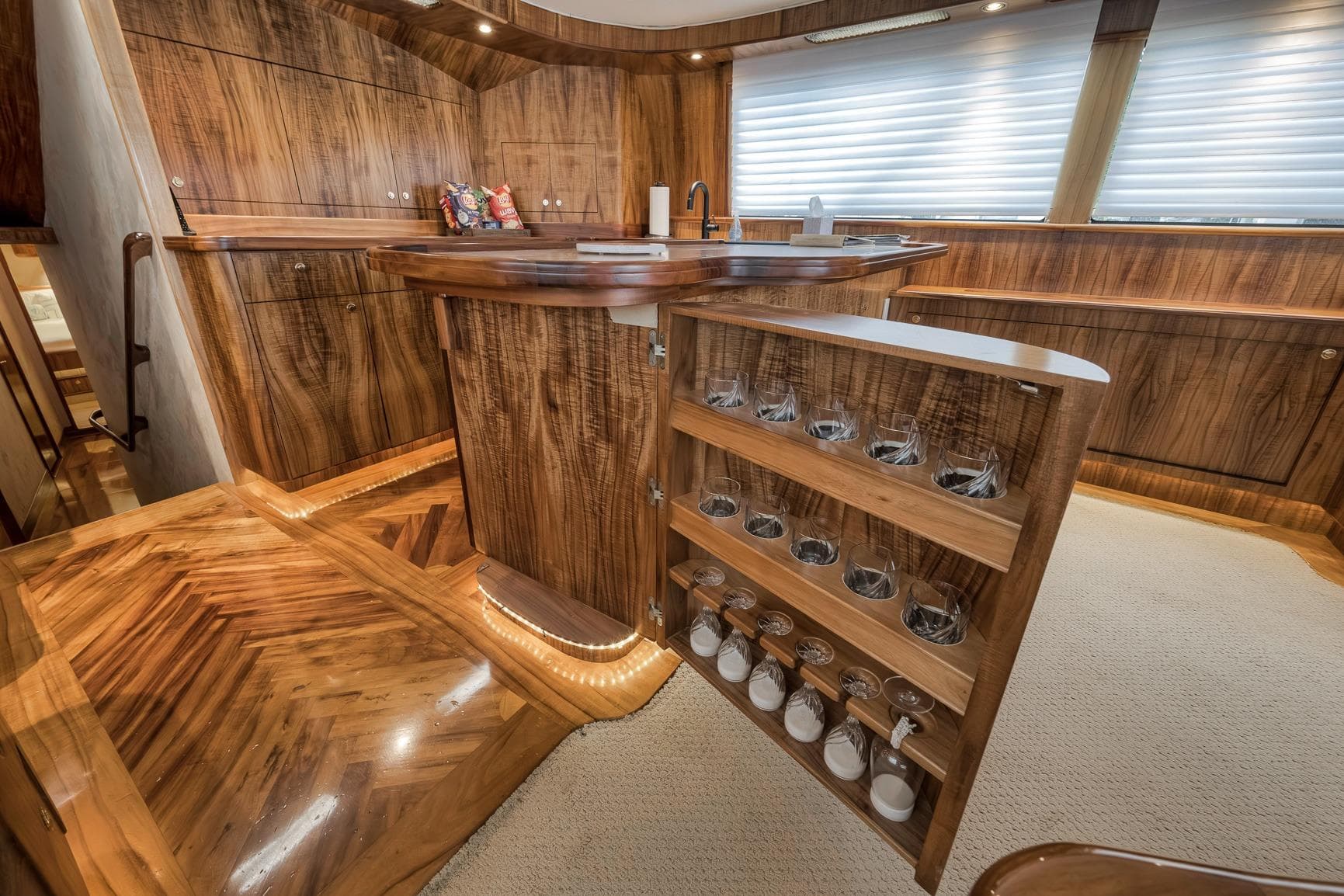 Luxurious 1999 Hines-Farley SPORTFISHERMAN yacht interior with elegant wood cabinetry and built-in glassware storage.