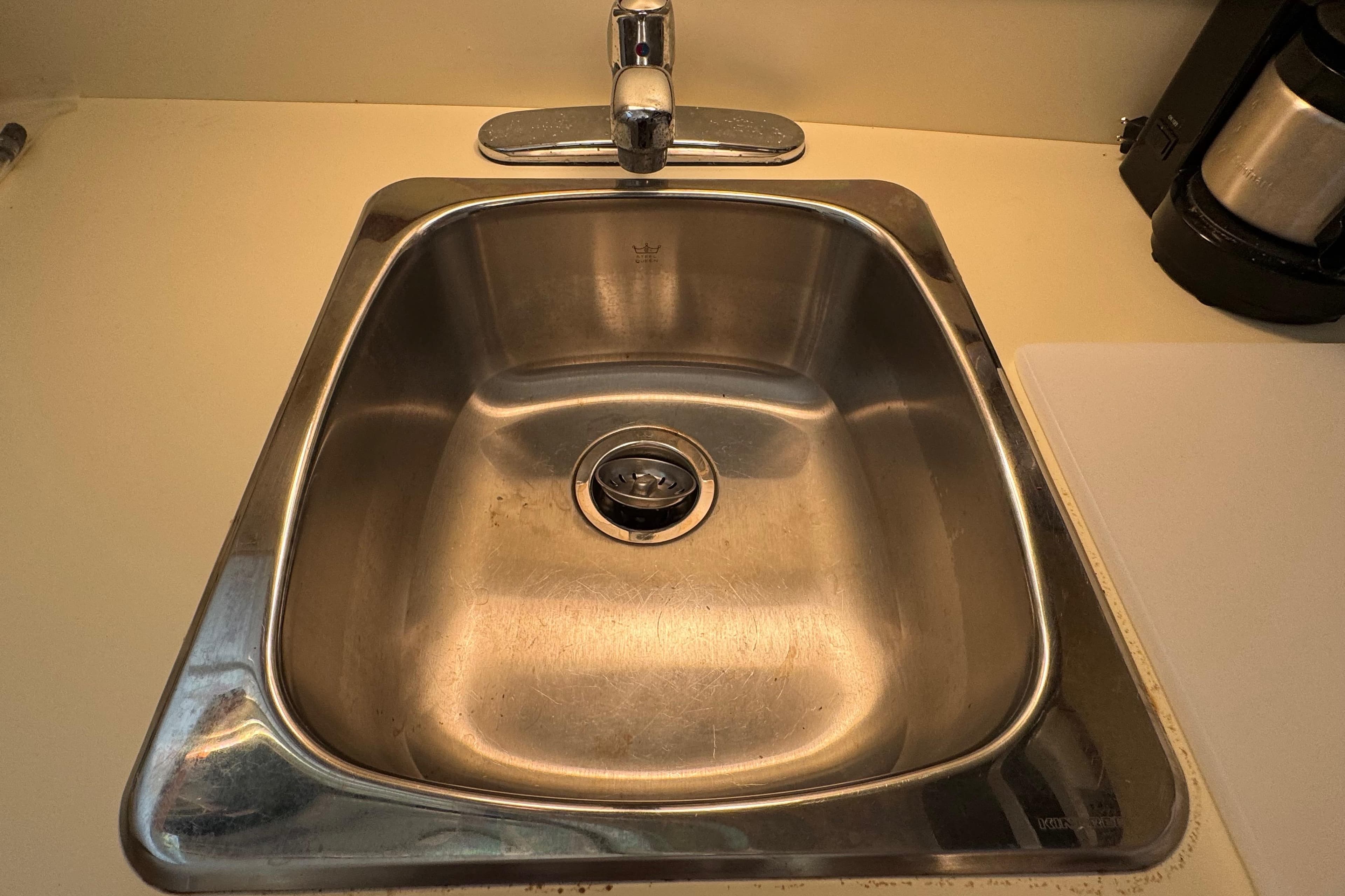 Stainless steel sink with faucet in a 2002 Camano Troller boat kitchen.