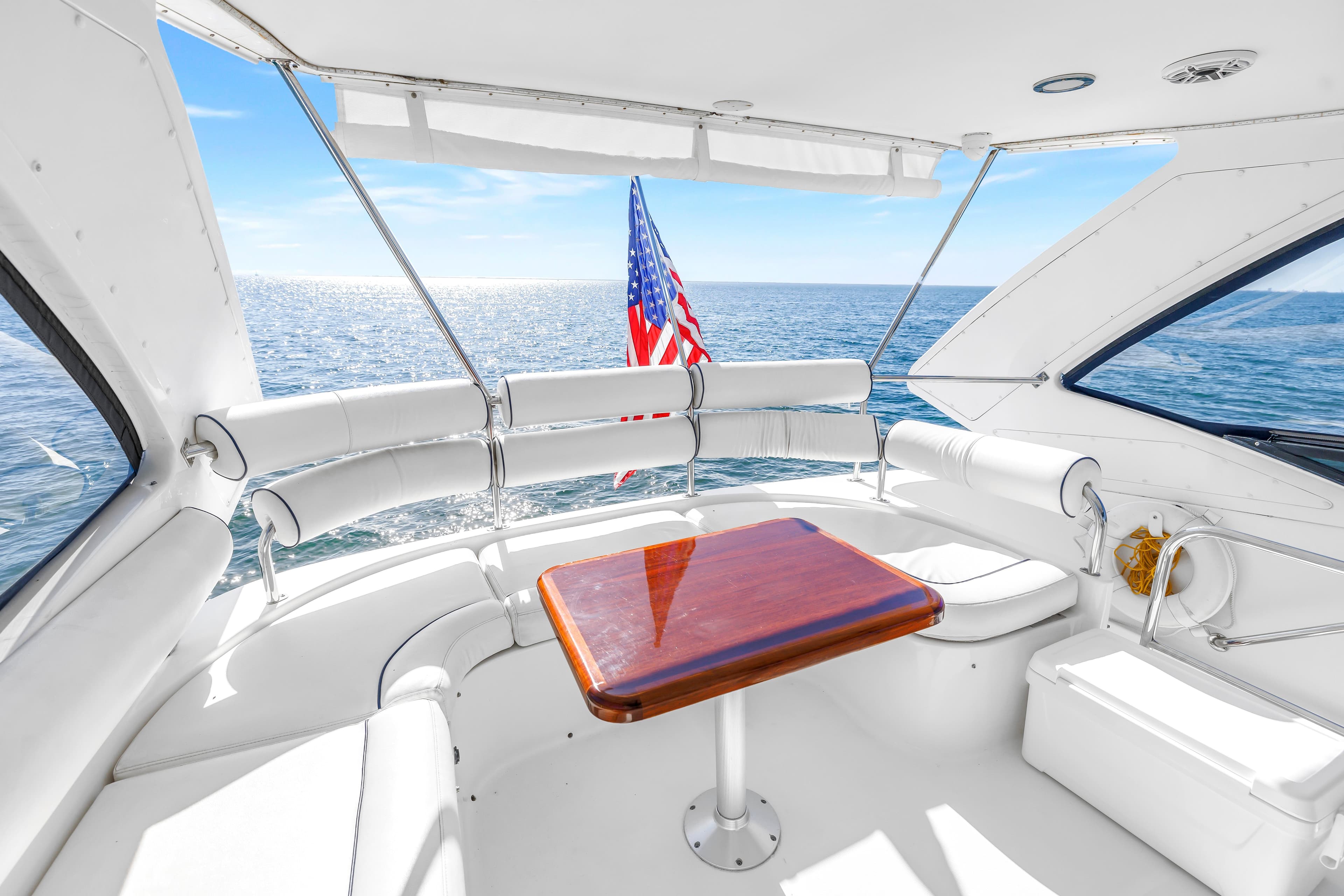 Luxurious 2001 Neptunus 56 Flybridge yacht interior with ocean view and American flag.