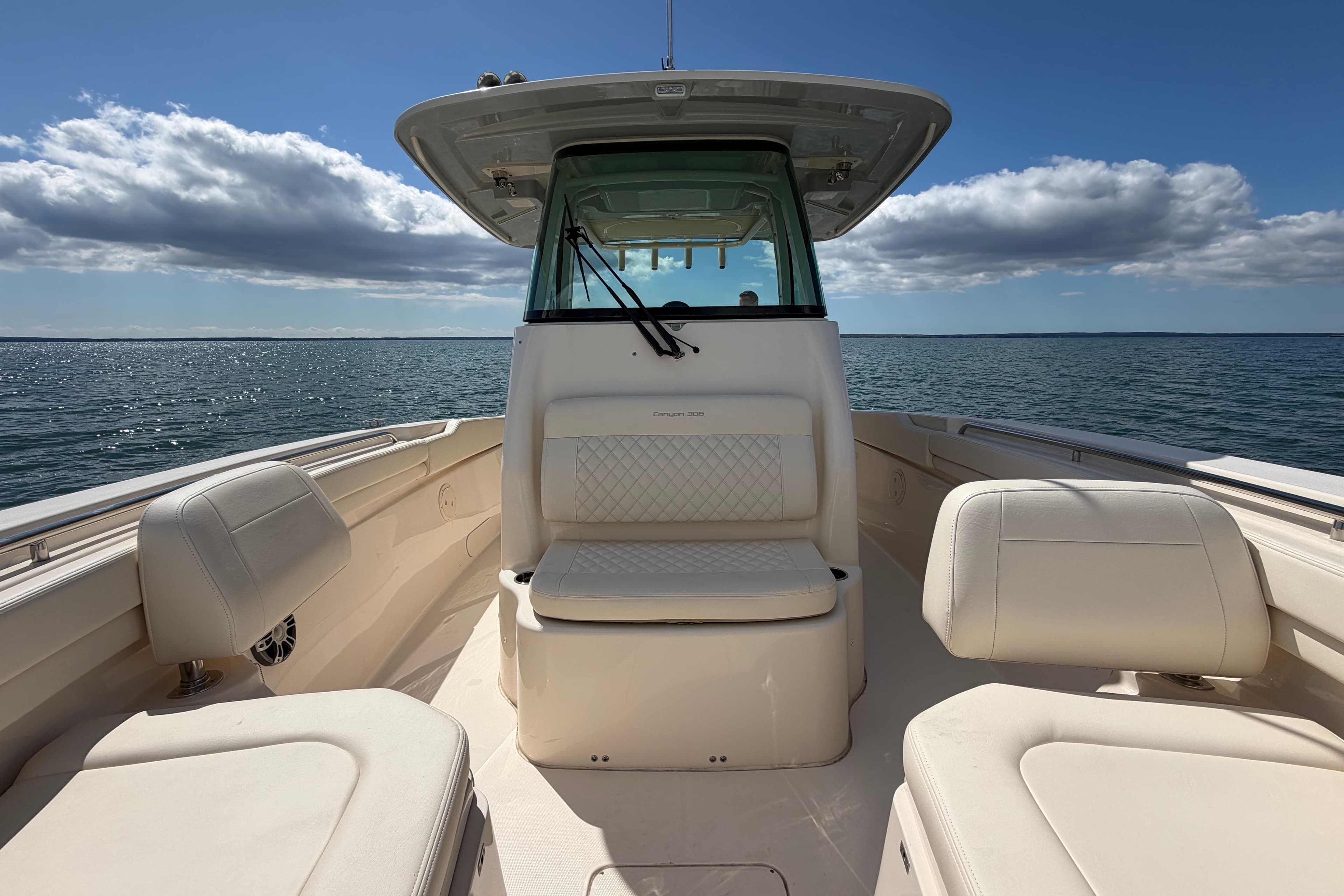 2026 Grady-White Canyon 306 boat interior with seating, on open water under blue sky.