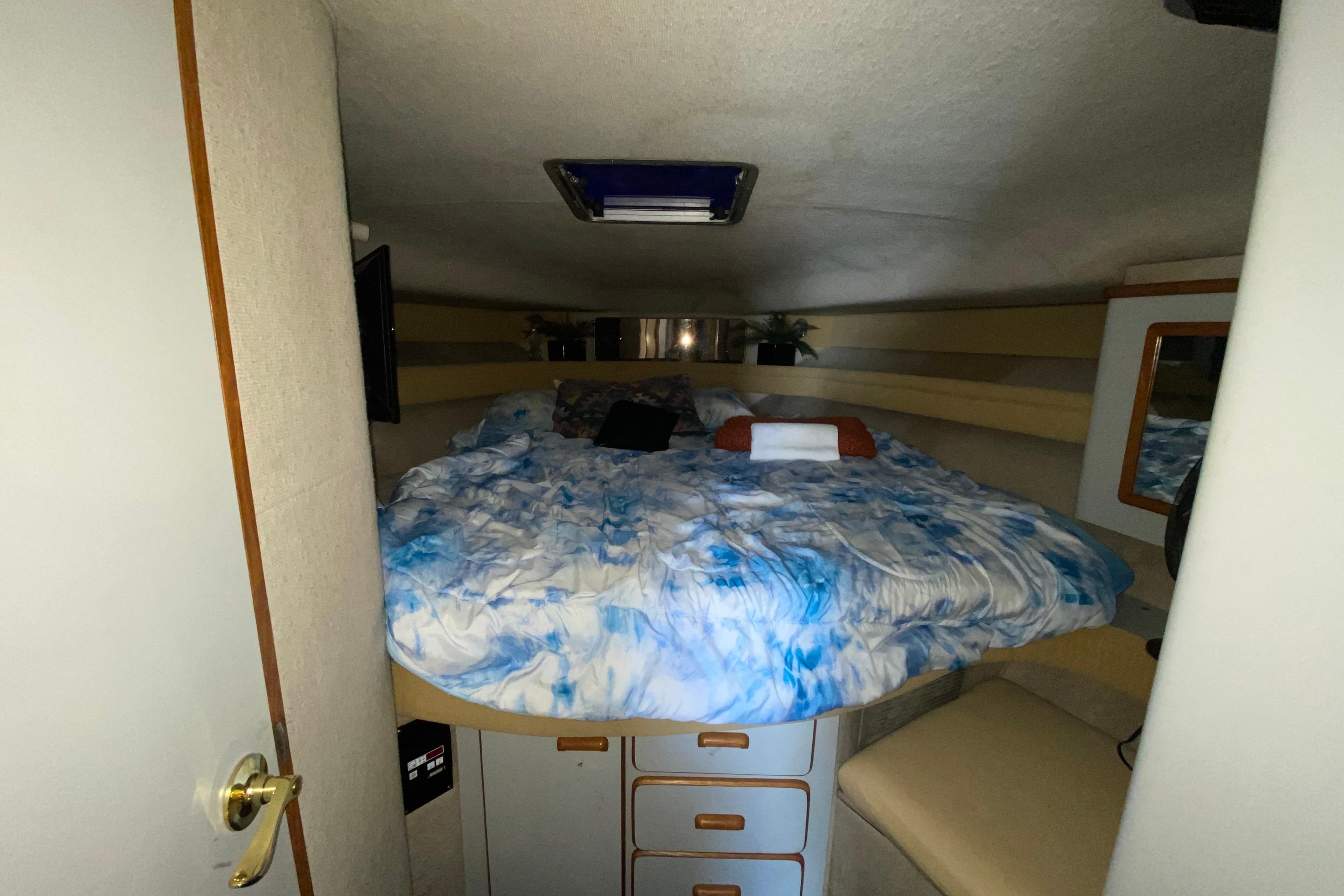 Cozy cabin interior of 1990 Sea Ray 420 Sundancer with bed and storage.