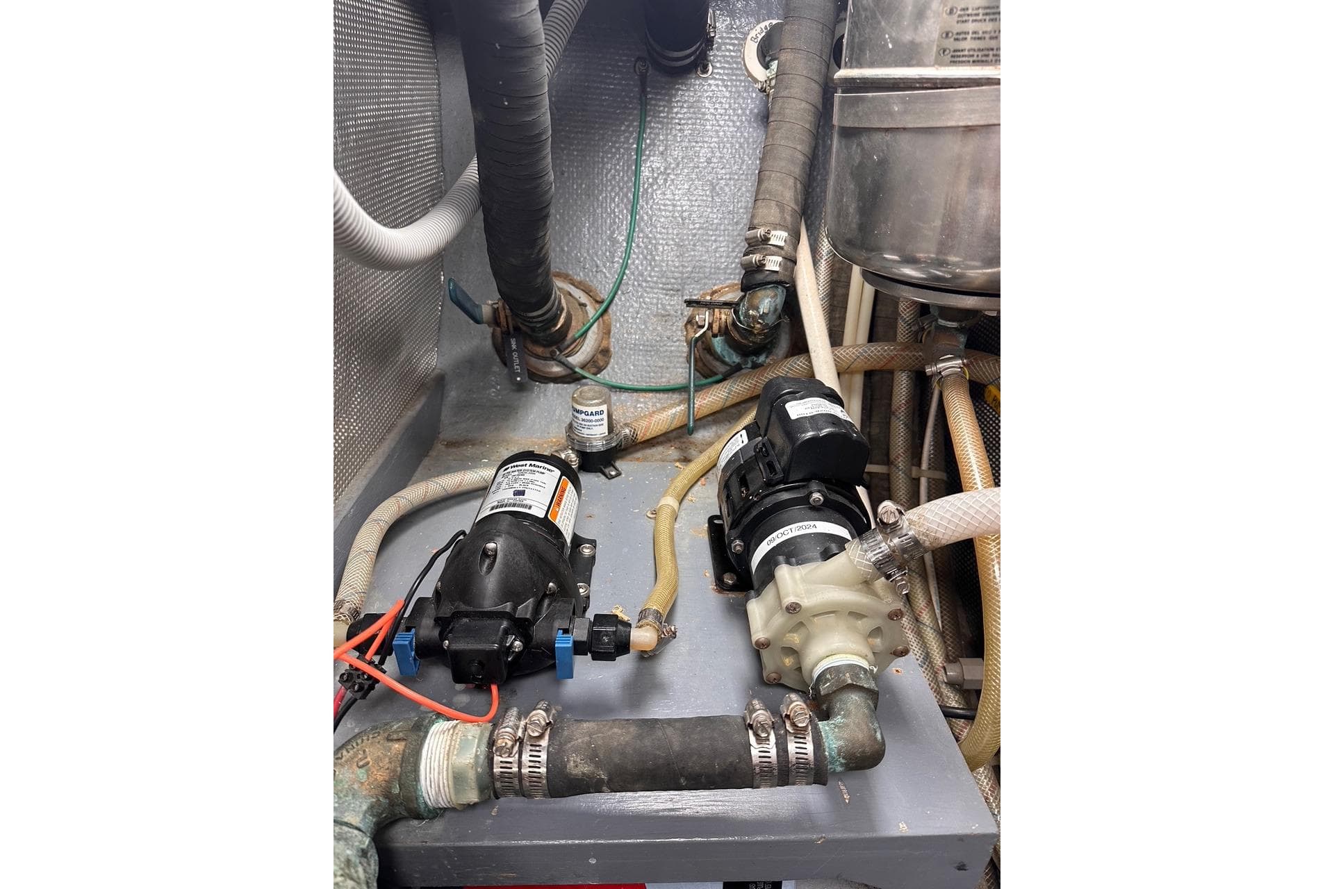 Engine room of a 1998 Nordhavn 46 yacht with pumps and hoses.