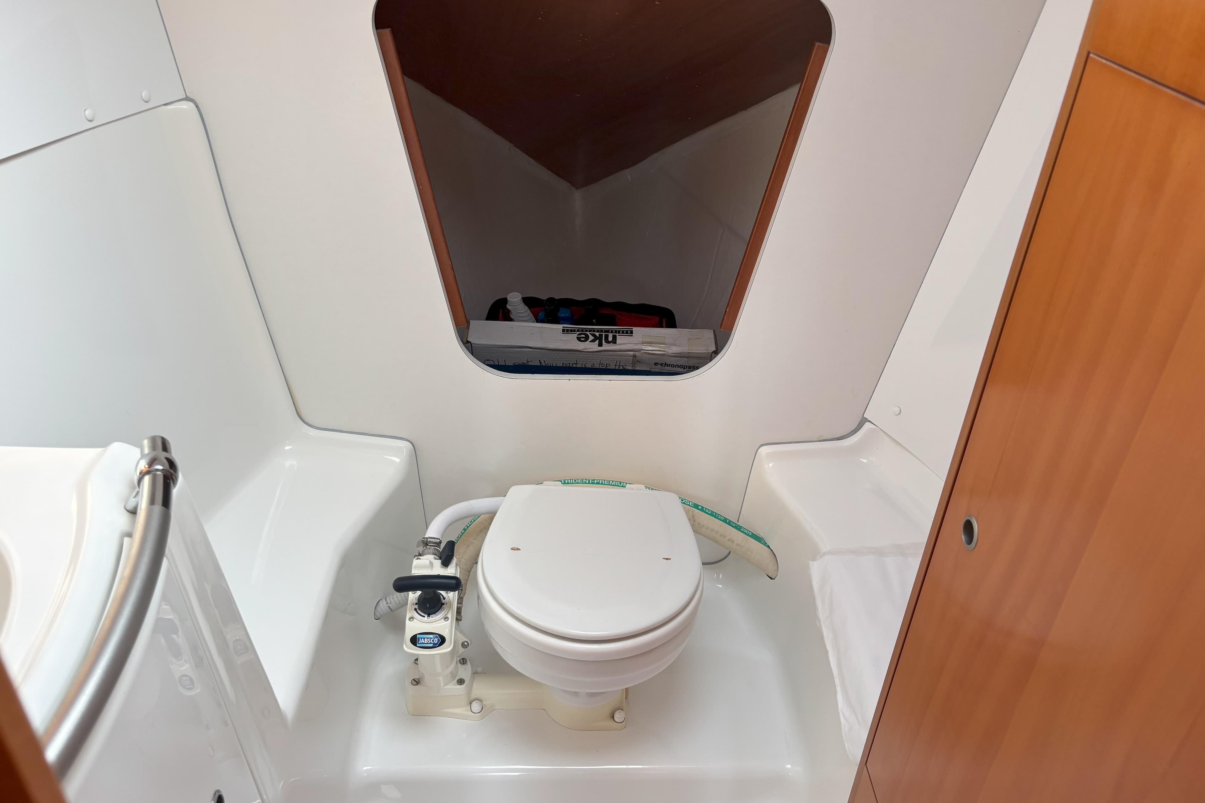2008 Beneteau First 10R yacht bathroom with compact marine toilet and storage space.