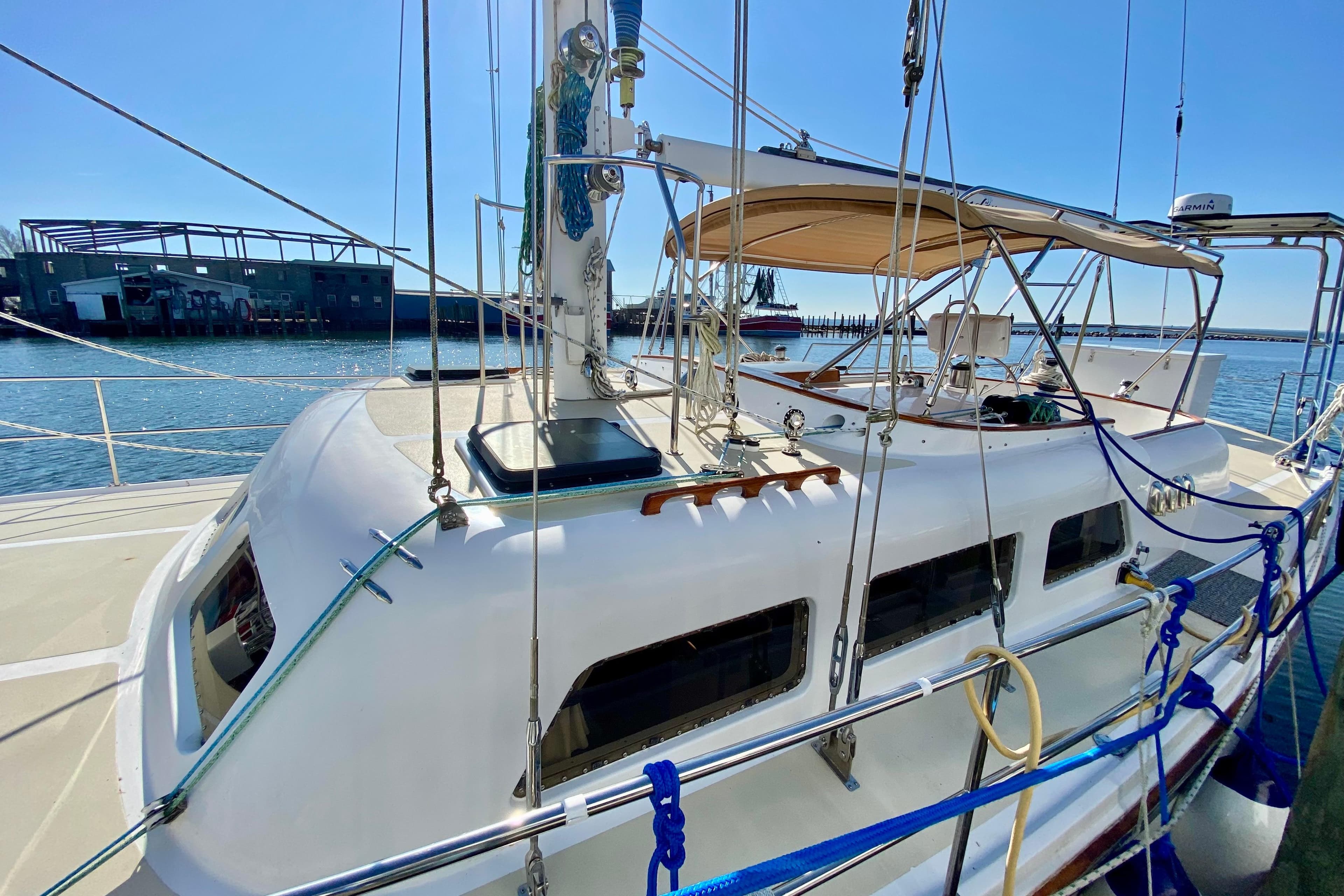 Sailboat docked at marina, Wellington 44 model, 1980, with clear blue sky.