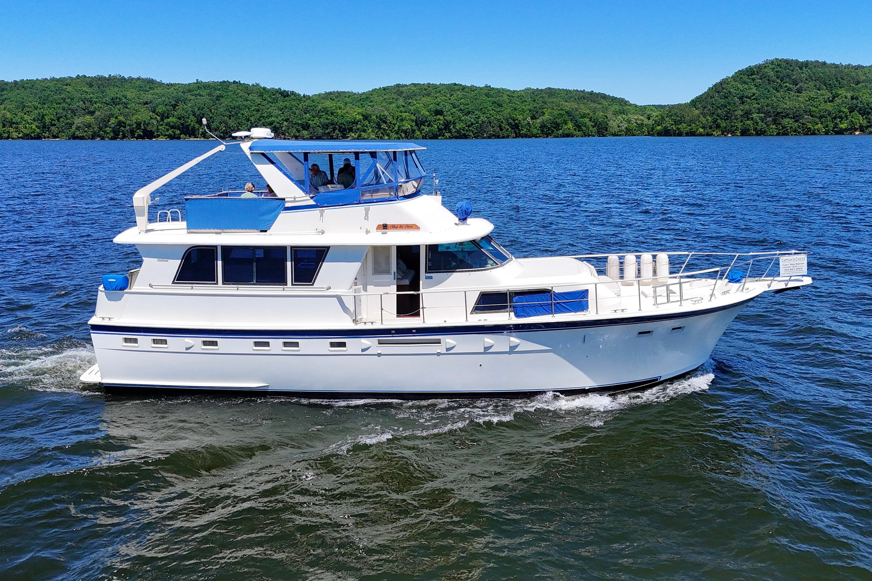 1984 Hatteras 53 Extended Deckhouse Motor Yacht cruising on a scenic lake.