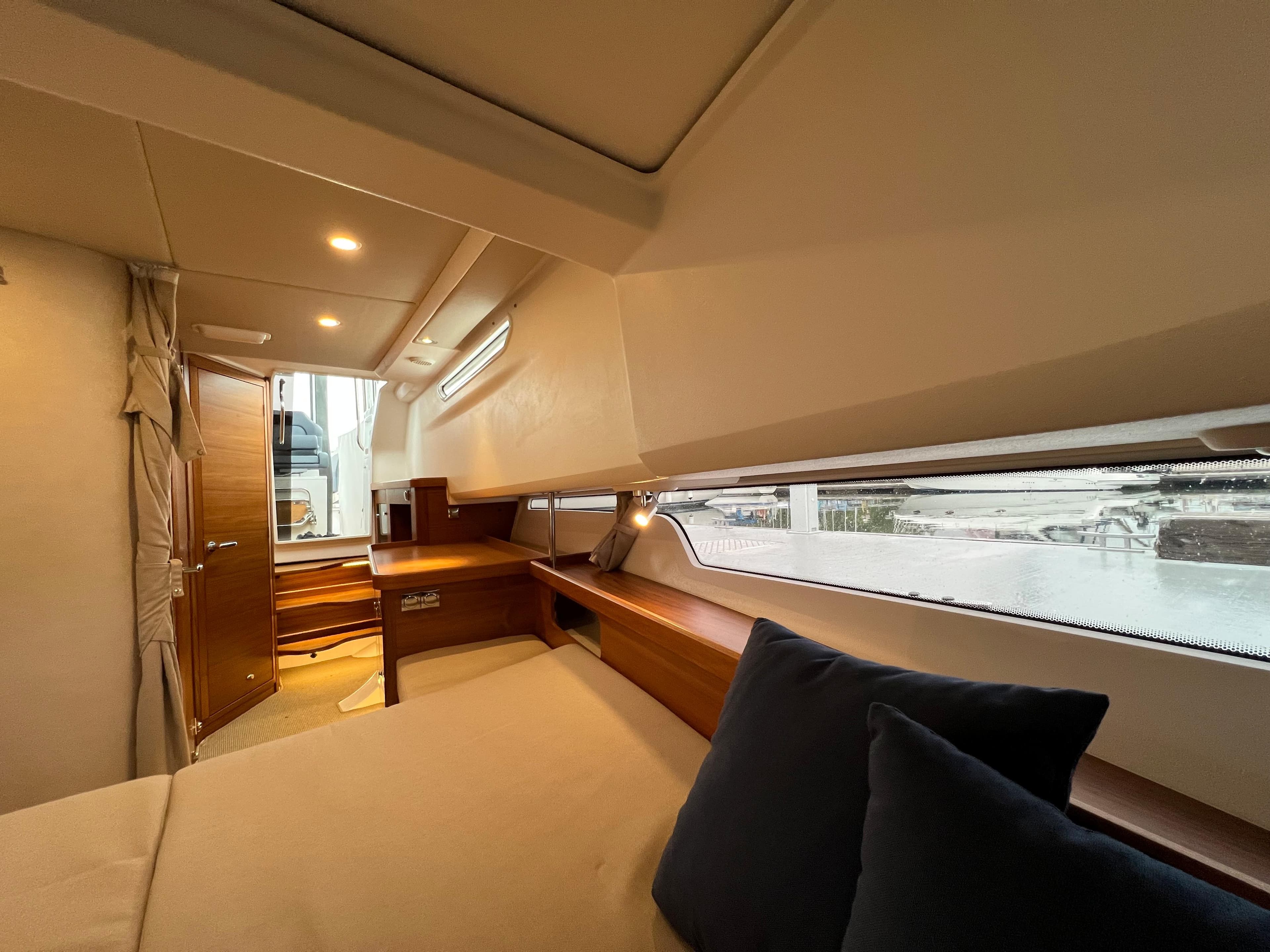 Interior of 2021 Nimbus Tender 11 boat, featuring cozy cabin with wooden accents and soft lighting.