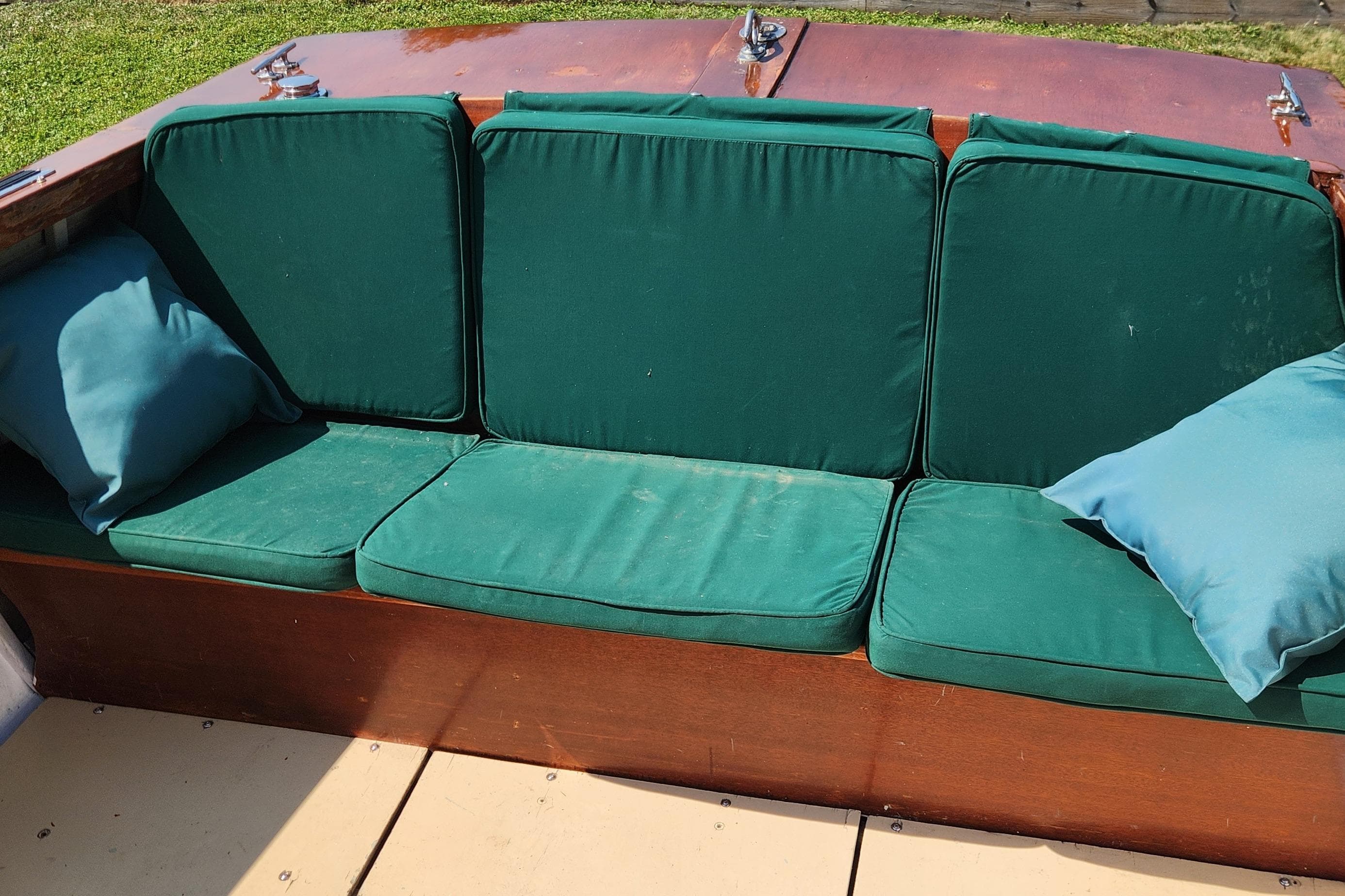 1958 Lyman Runabout boat with green cushioned seating and blue pillows.