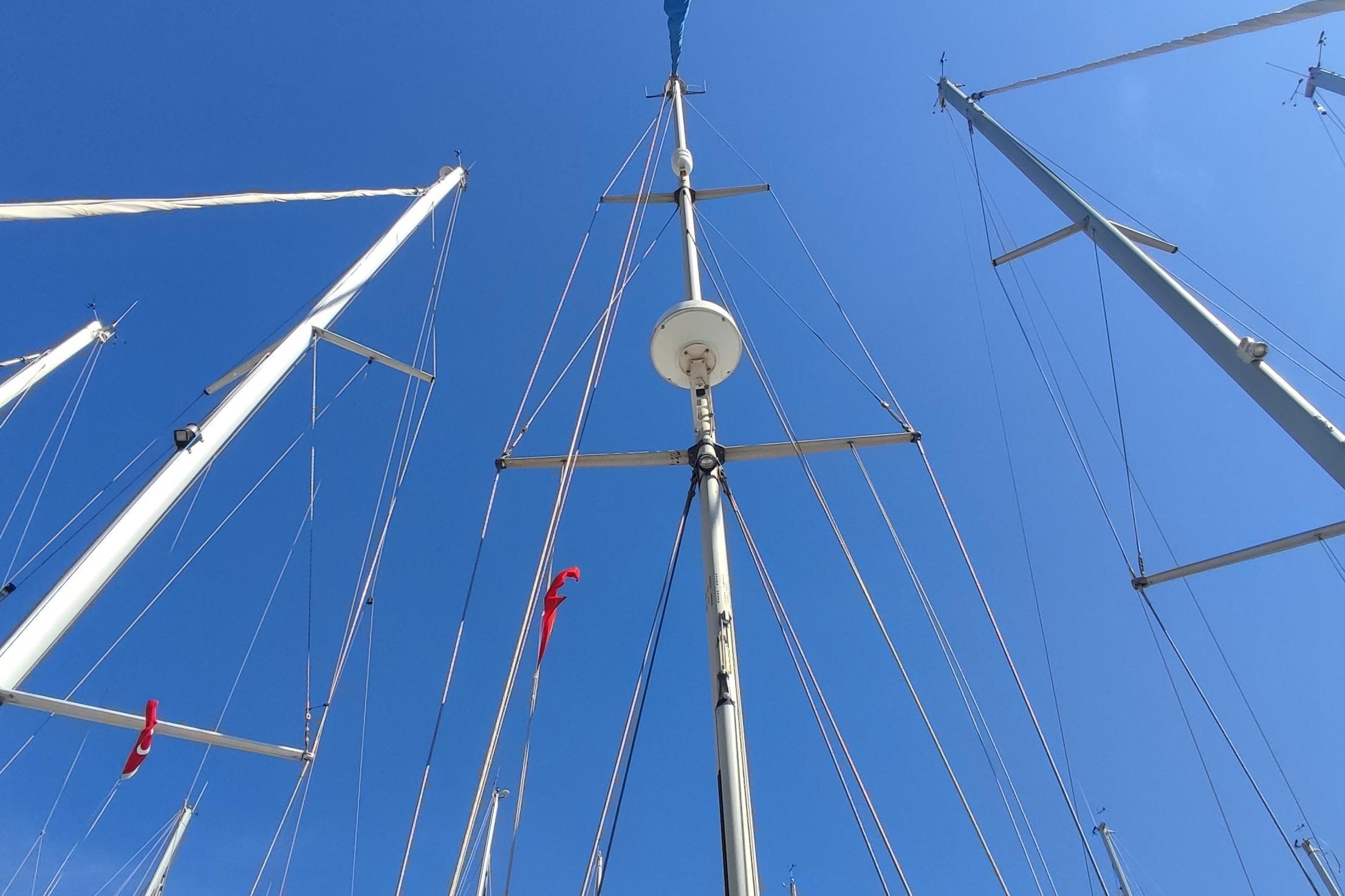 Tall masts of a 1997 Nauticat 42 sailboat against a clear blue sky.