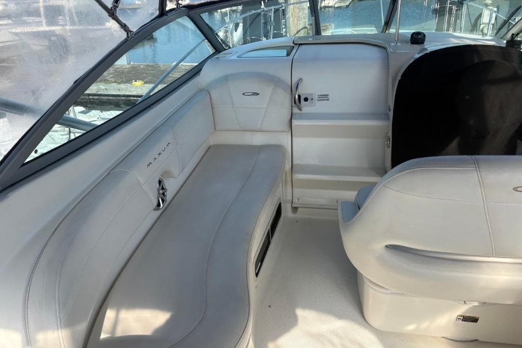 Interior of a 2008 Maxum 2700 SE boat, featuring white seating and sleek design.