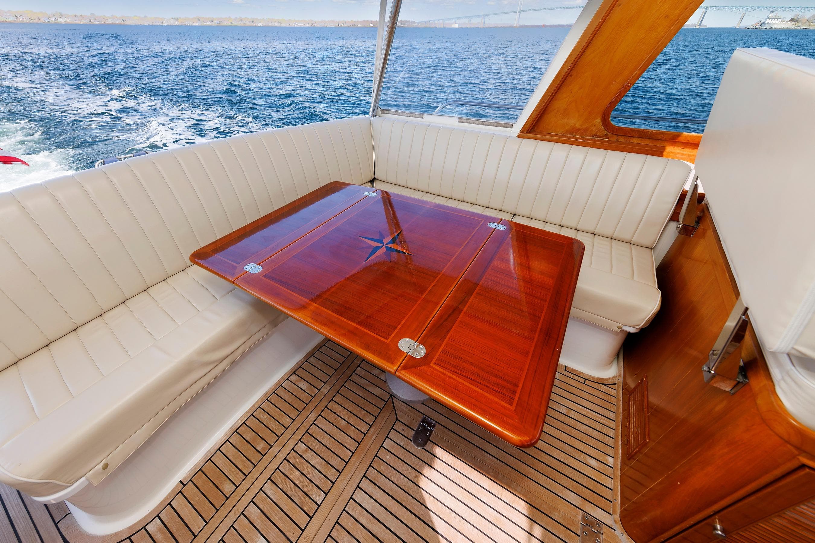 Luxurious Eastbay 49 yacht interior with elegant wood table and white seating, 2000 model.
