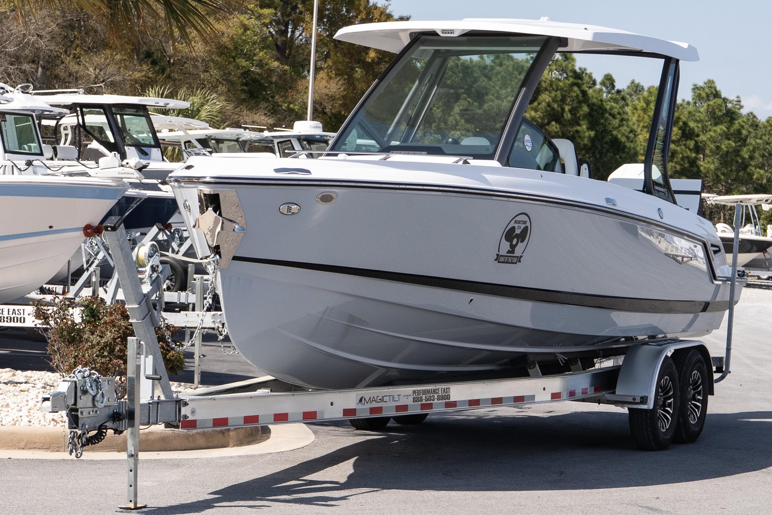 2026 Monterey Elite 27 OB boat on trailer, parked outdoors.