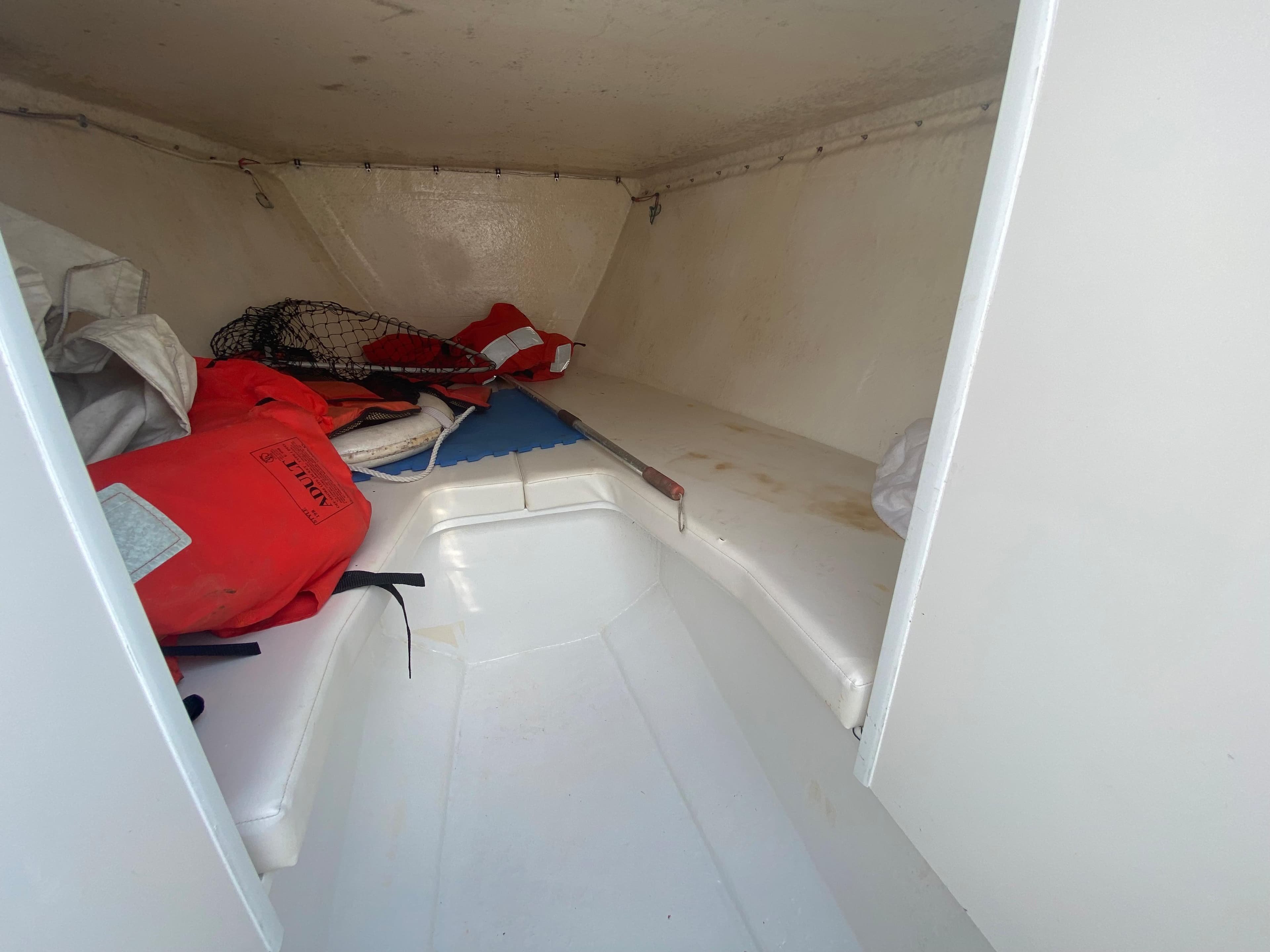 2006 Kryptonite 41 CC boat interior with life jackets and fishing gear.