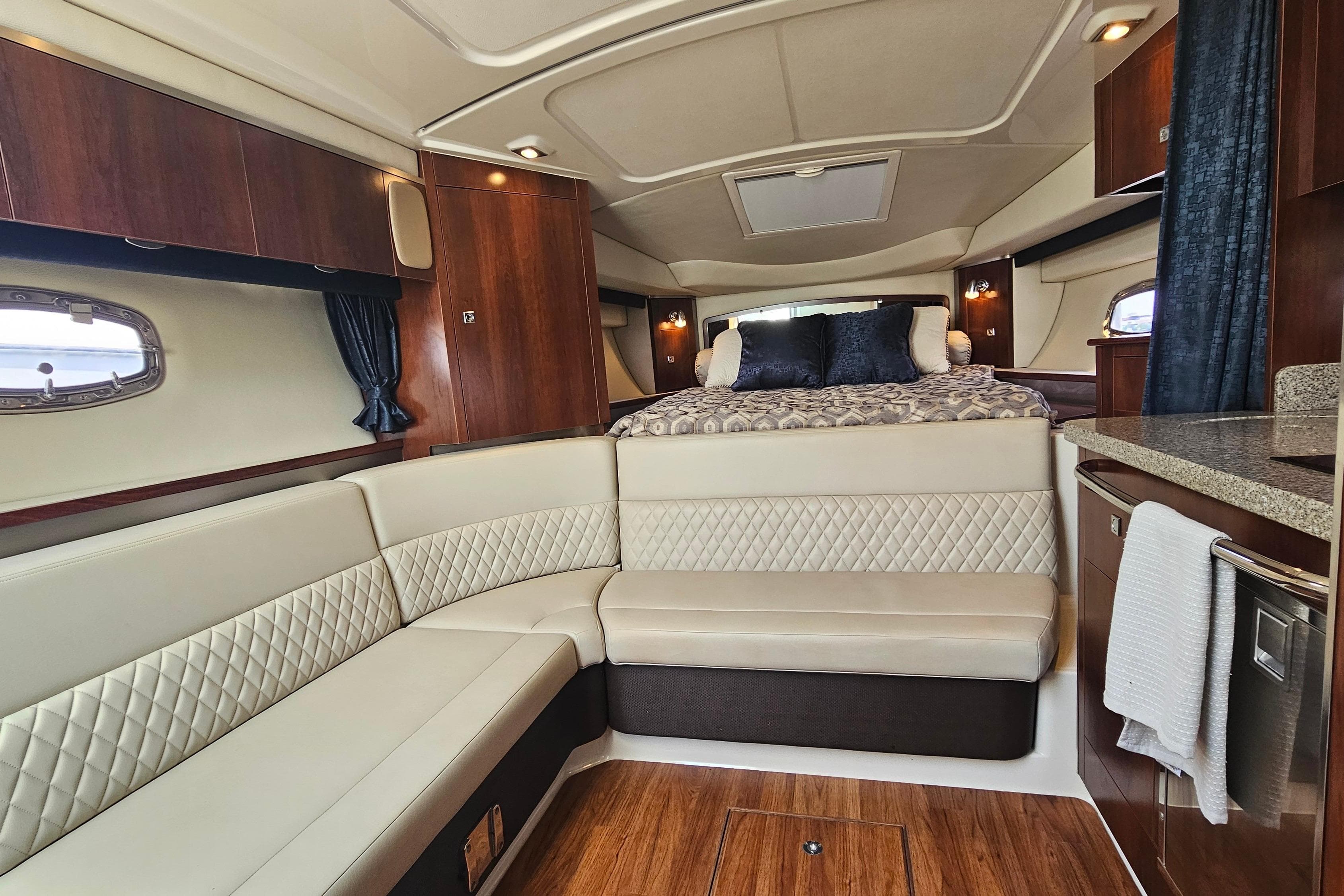 Luxurious interior of 2015 Chaparral 310 Signature yacht with elegant seating and cozy bed.