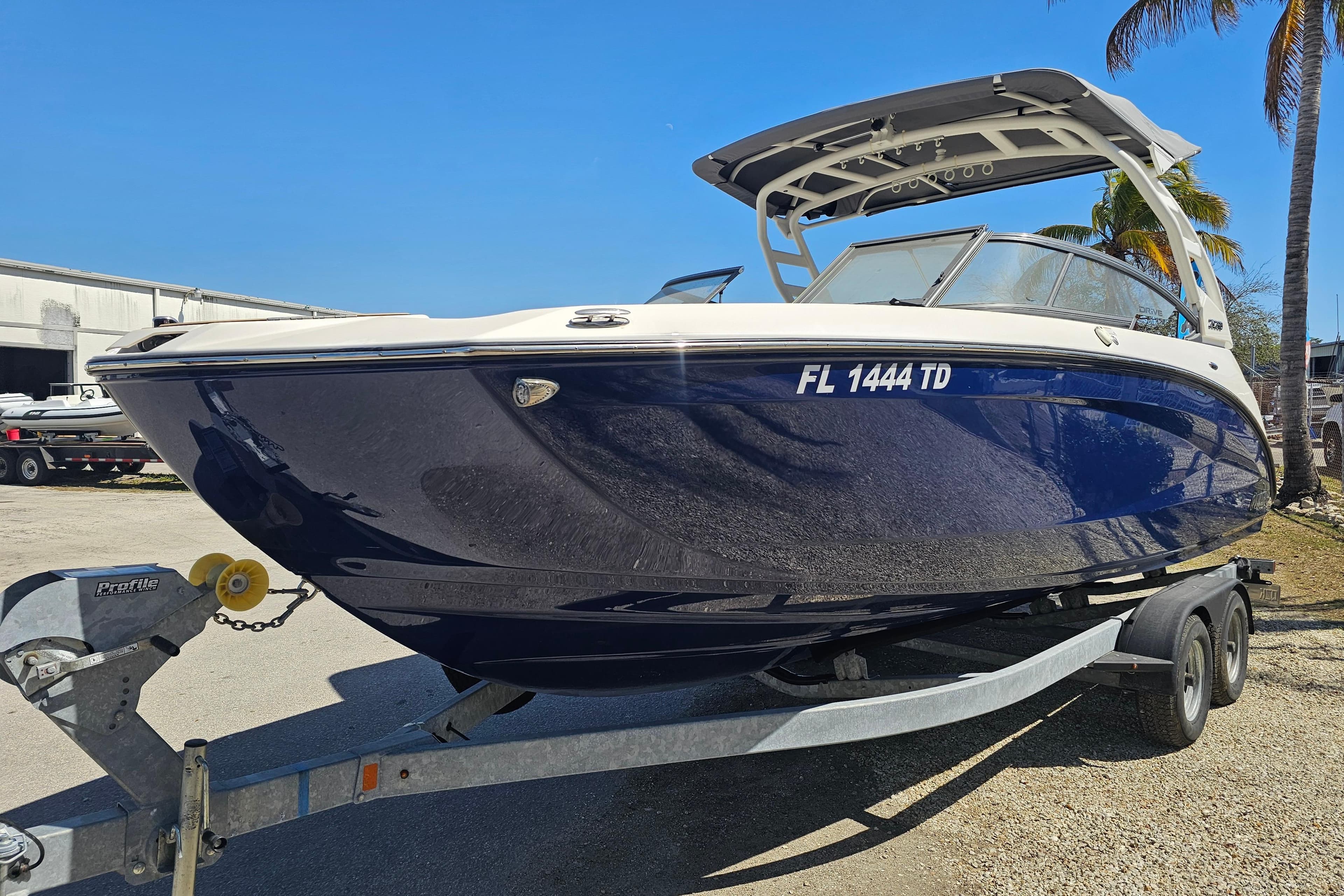 2022 Yamaha Boats 252SD on trailer, sleek blue design under clear sky.