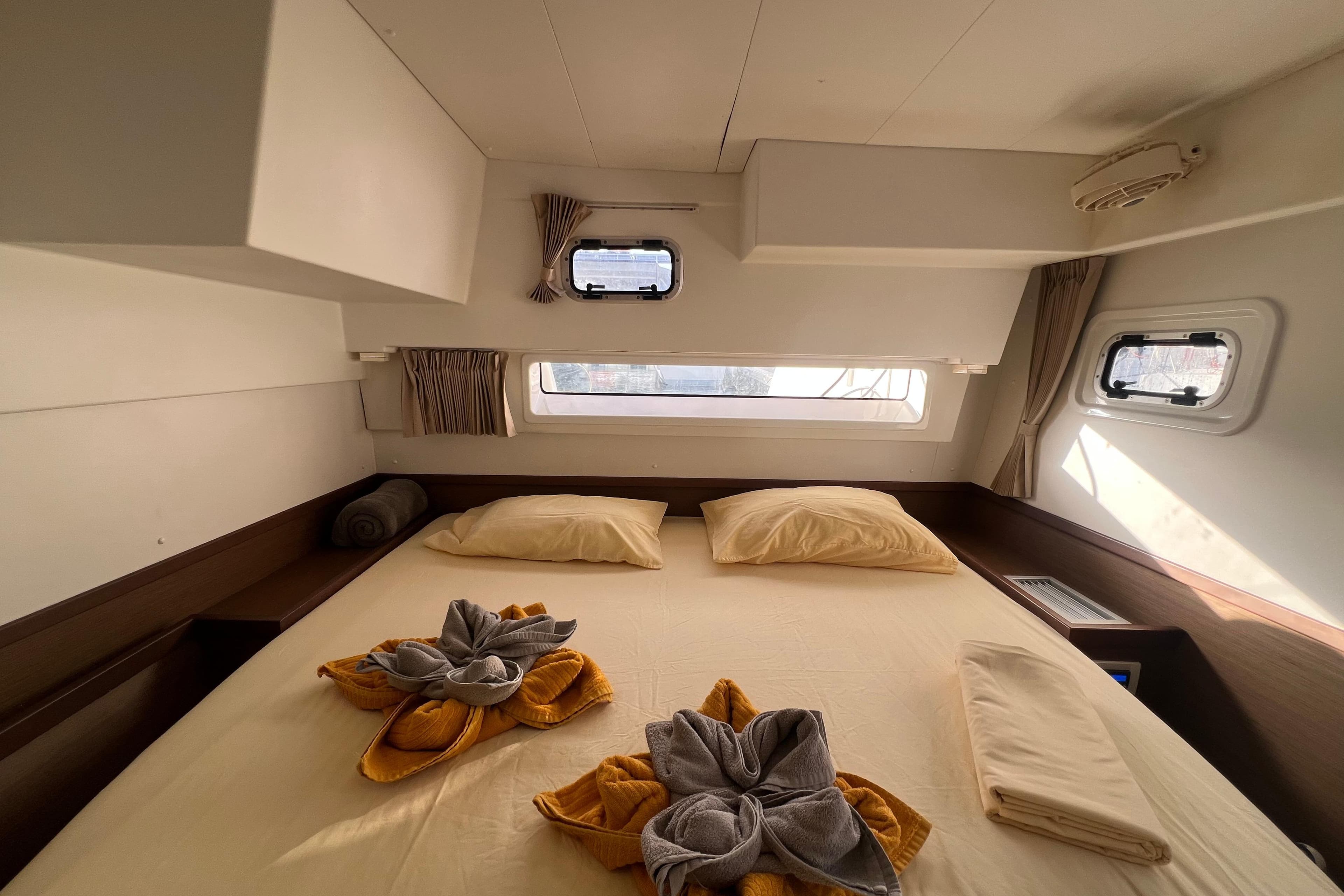 Luxurious cabin interior of a 2018 Lagoon 42 catamaran with neatly arranged bedding.