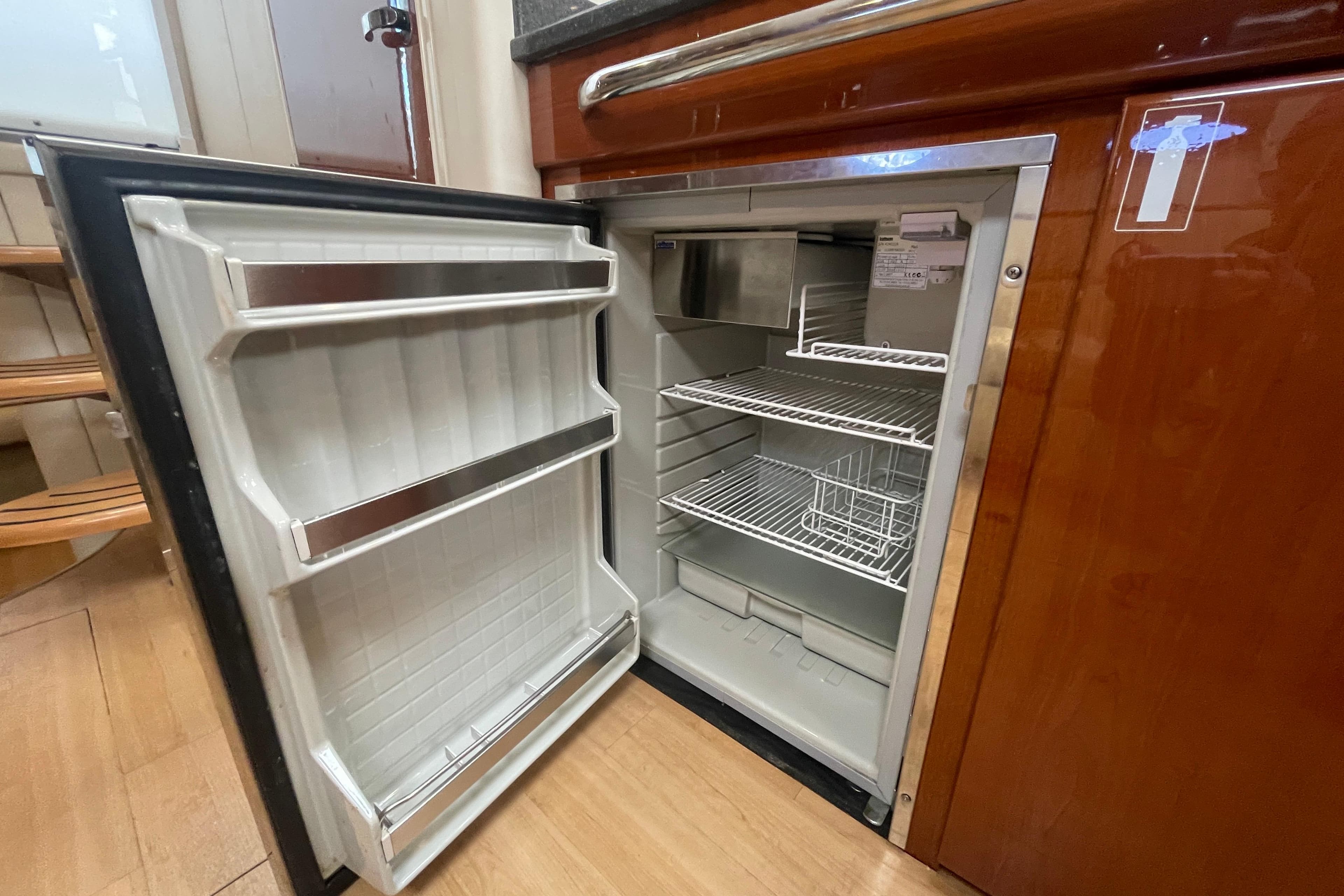 Open refrigerator inside 2011 Formula 34 Performance Cruiser, showcasing interior shelves and door storage.