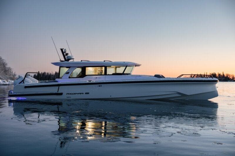 2026 Axopar 38 Cross Cabin boat on calm water at sunset.