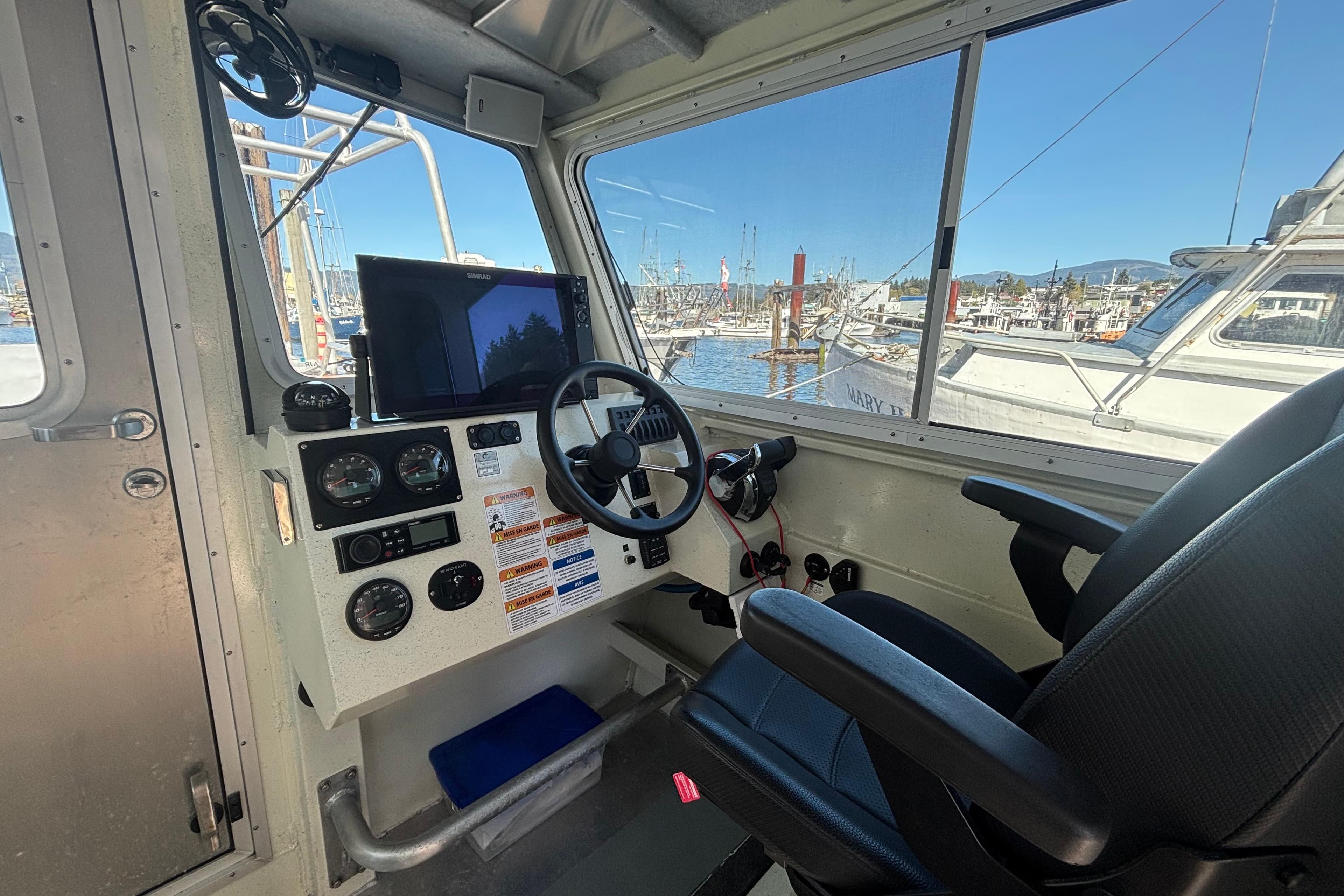 Interior of 2021 Silver Streak 32 Landing Craft Cabin, featuring control panel and harbor view.