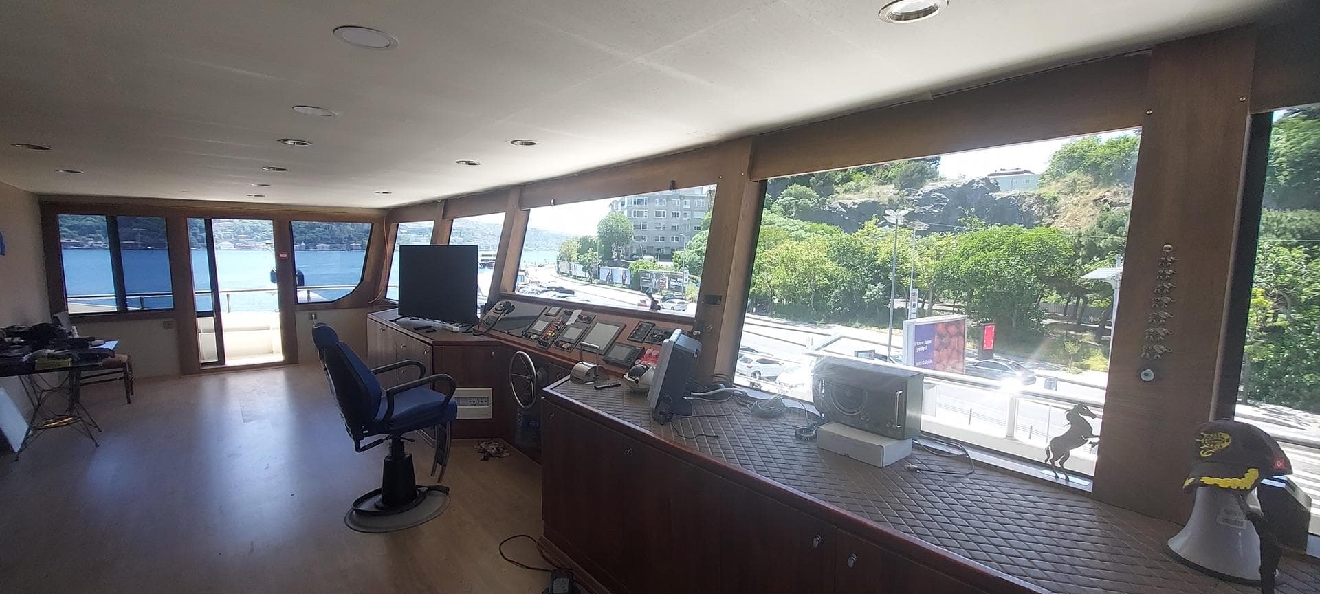 Interior of a 2025 Custom-Craft restaurant and excursion vessel with panoramic windows and modern controls.