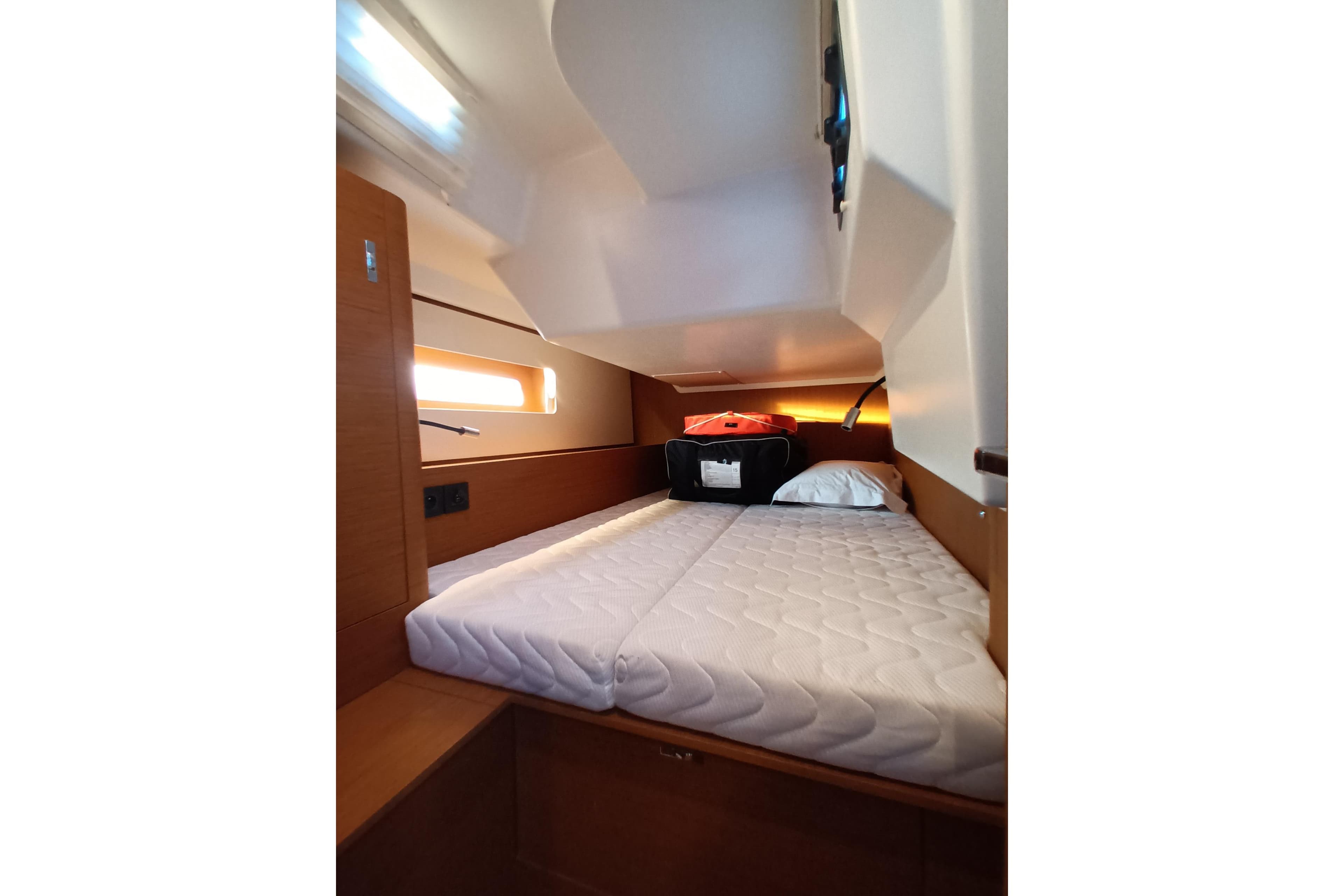 Cozy cabin interior of 2025 Beneteau First 44 yacht with comfortable bedding.