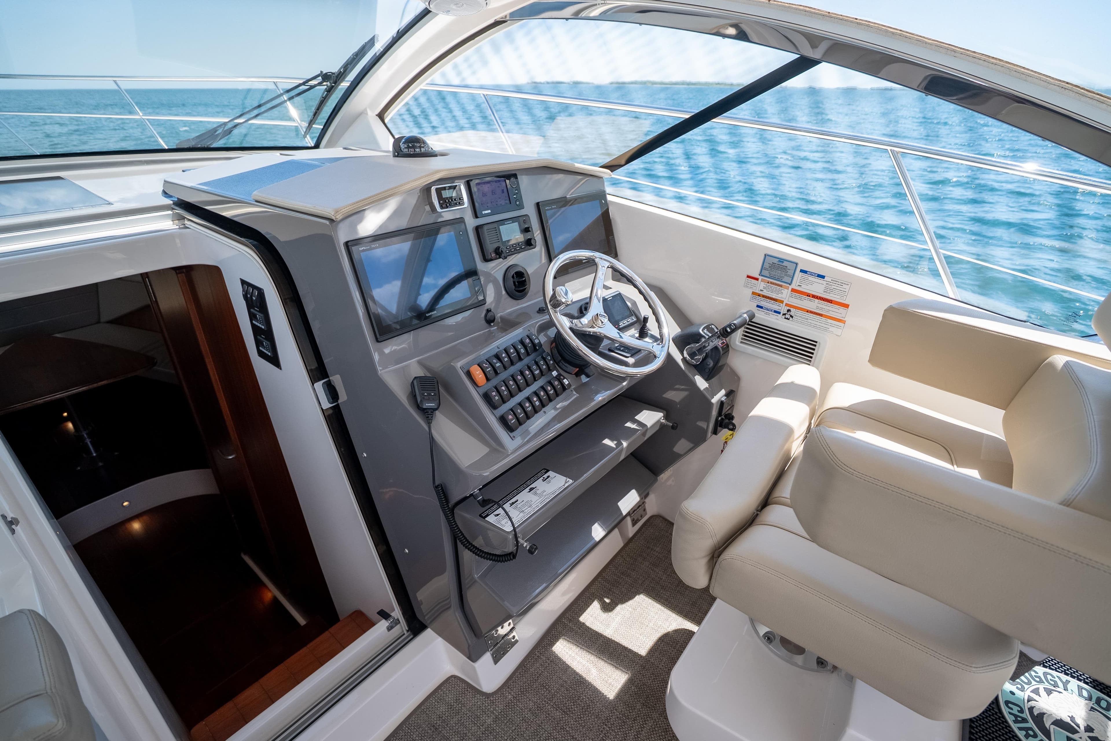 Helm of 2015 Pursuit SC 365i Sport Coupe with modern controls and ocean view.