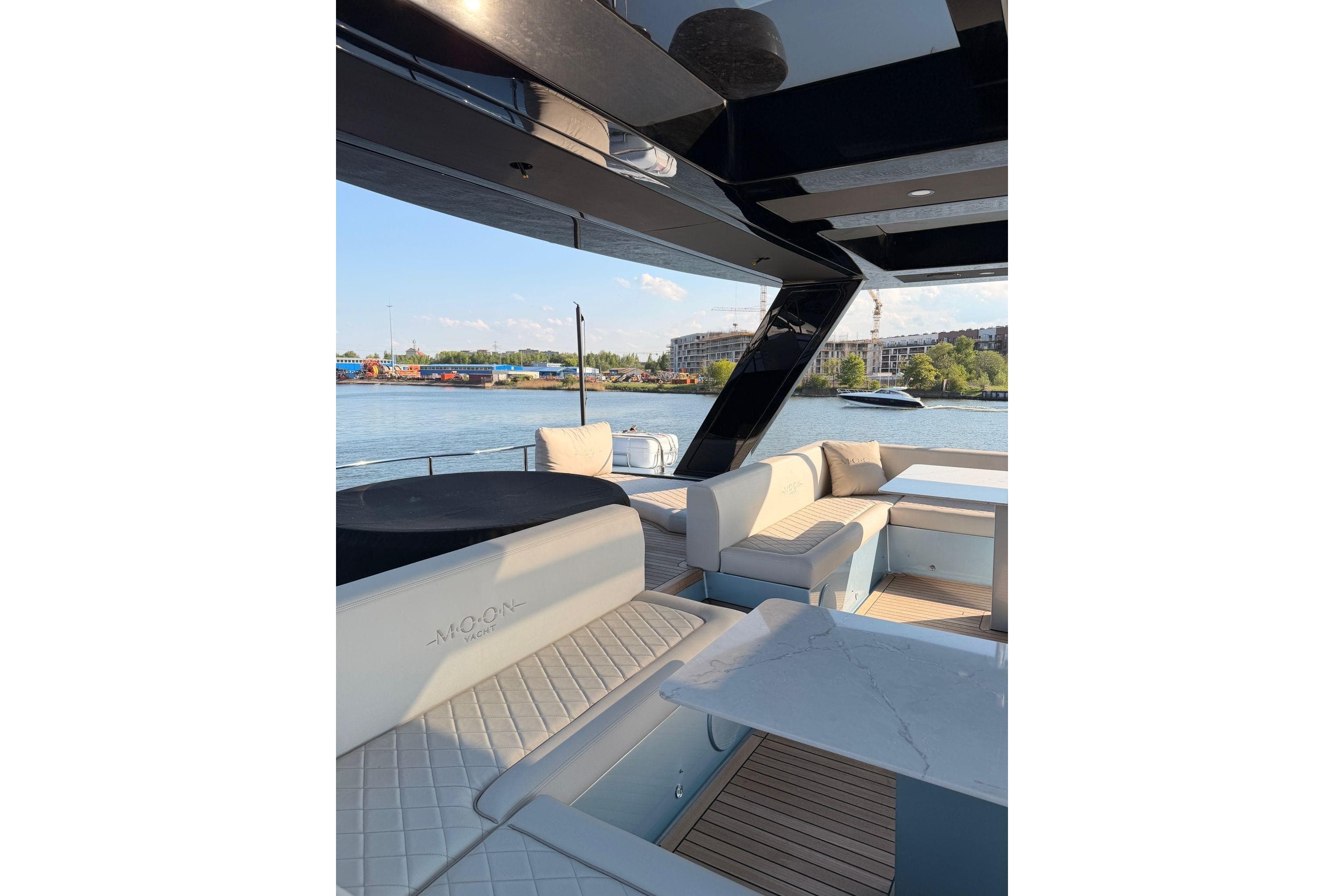 Luxurious 2026 Moon 60 Power yacht interior with elegant seating and scenic waterfront view.