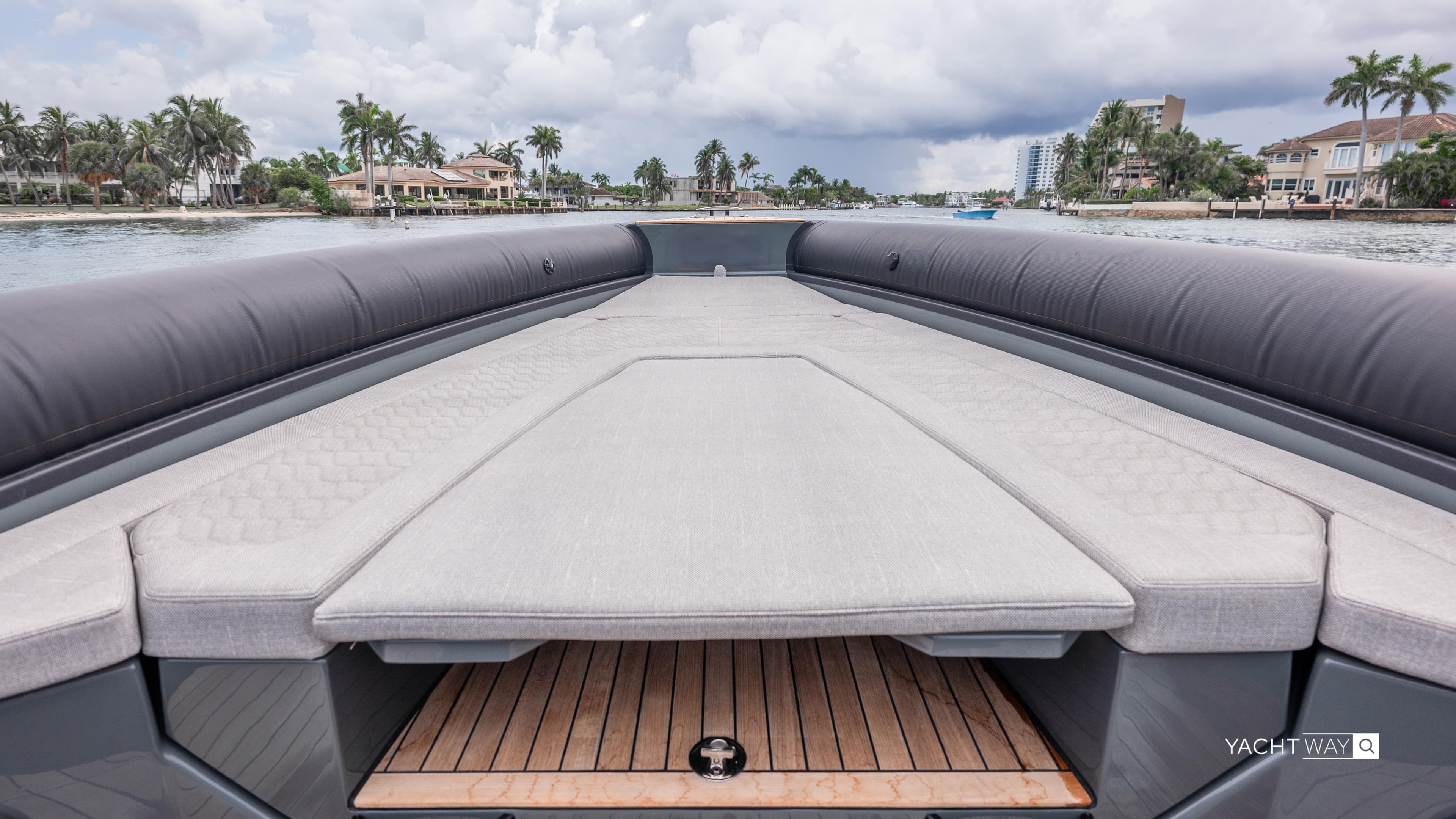 Luxurious 2025 Skipper-BSK 38NC yacht deck with cushioned seating, overlooking waterfront homes.