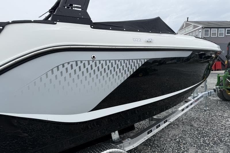 2026 Bayliner D22 boat on trailer, featuring sleek black and white design.