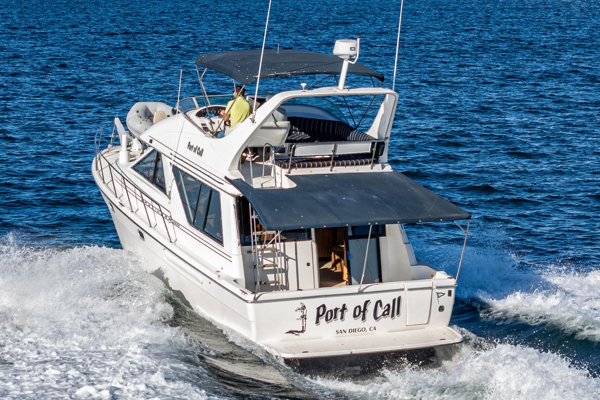 1998 Bayliner 3988 Motoryacht cruising on open water, rear view.