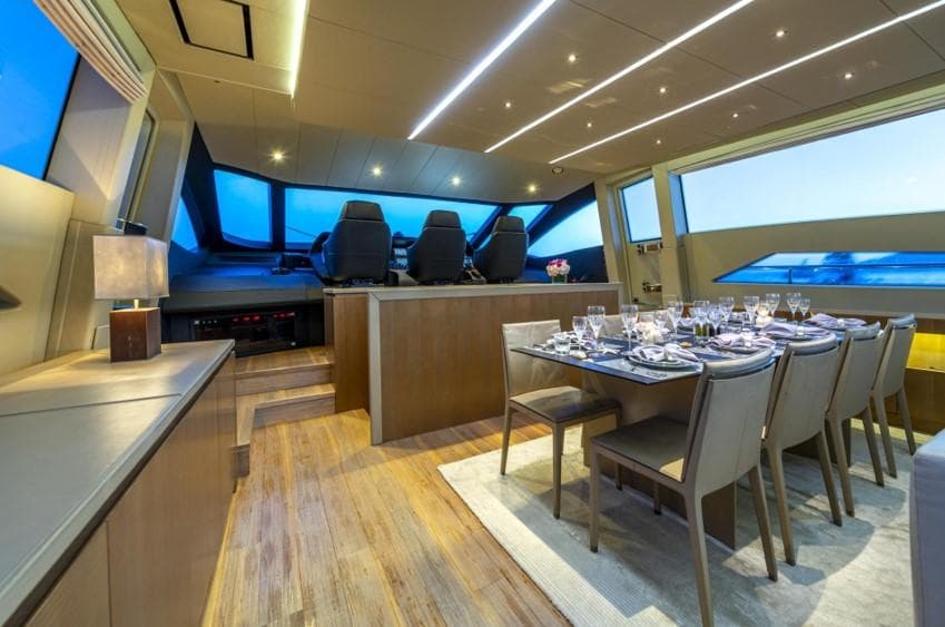 Luxurious interior of 2013 Pershing 108 yacht with elegant dining area and modern helm.