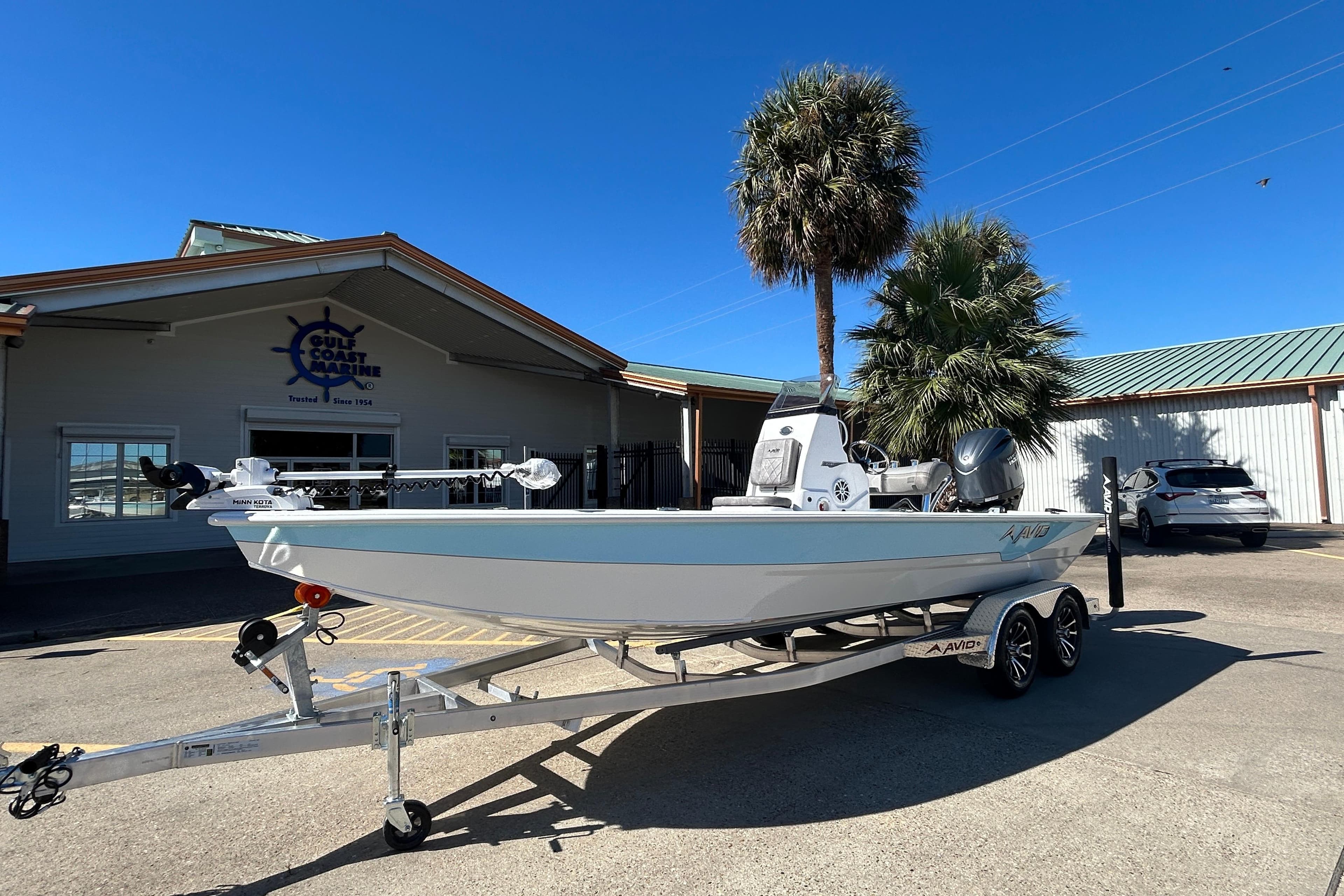 2025 Avid 21 FST boat on trailer outside Gulf Coast Marine dealership.