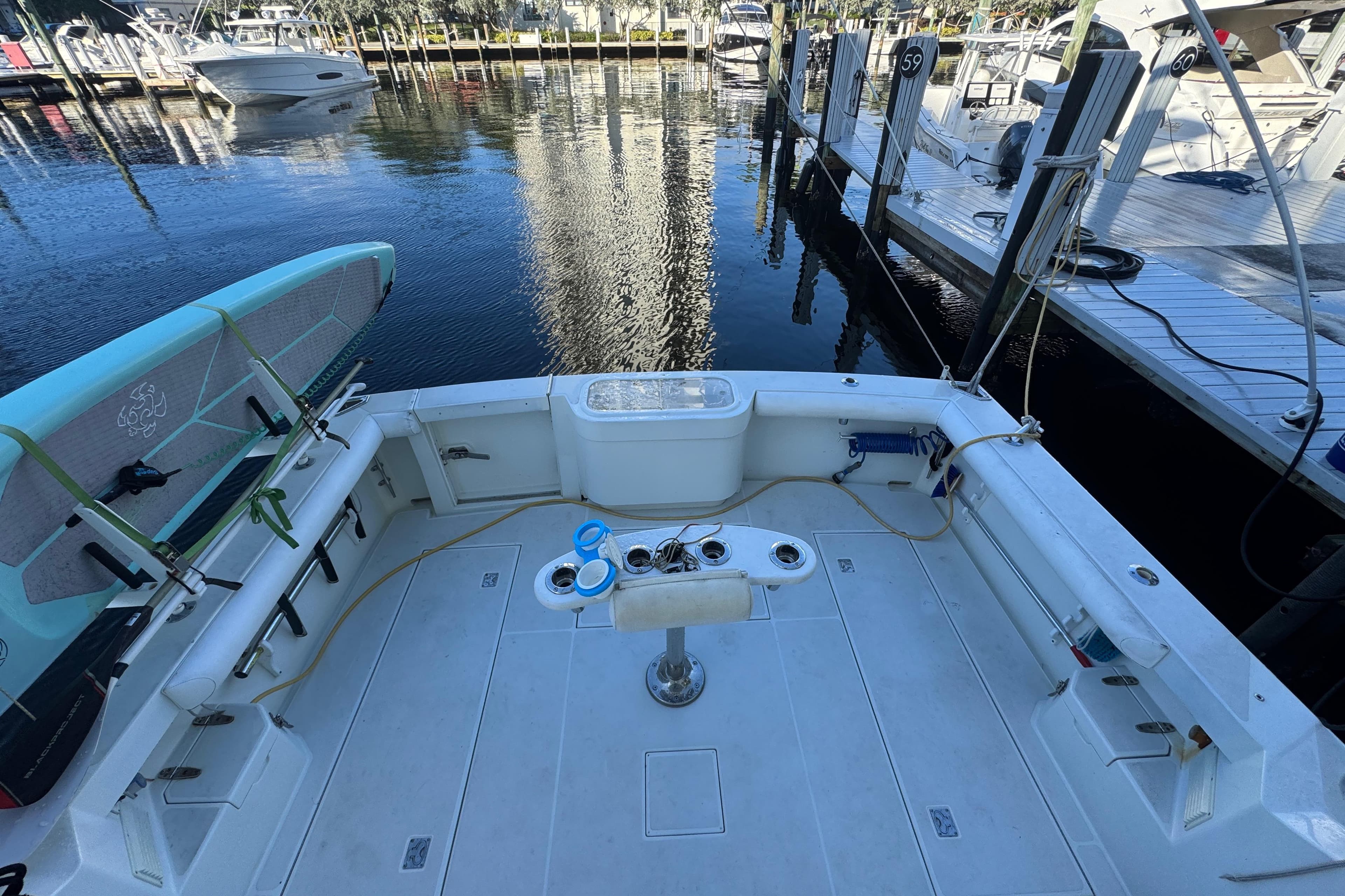 2001 Cabo 35 Express boat deck with fishing setup, docked at marina.