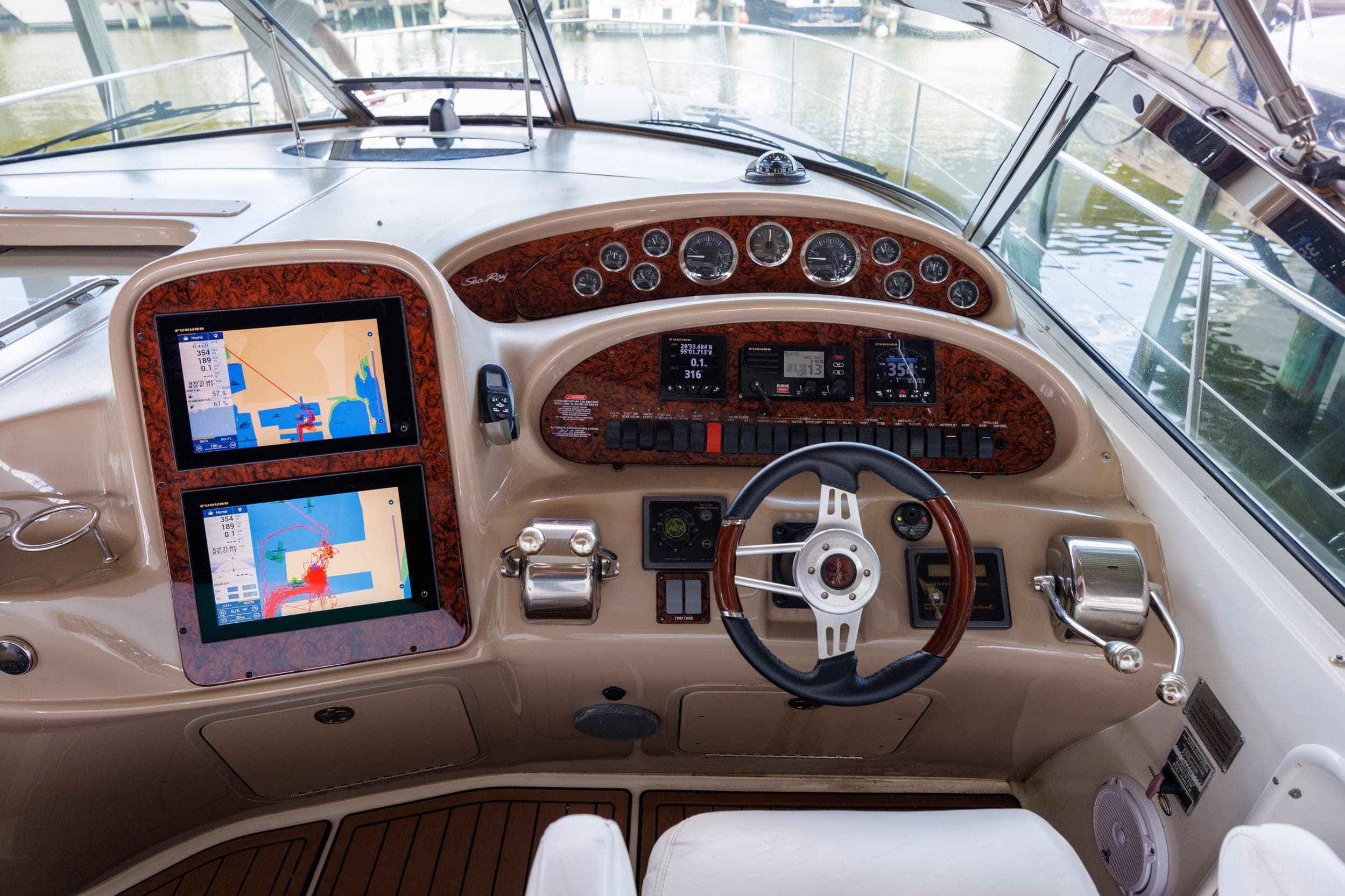 Cockpit of 2002 Sea Ray 410 Express Cruiser with navigation screens and steering wheel.