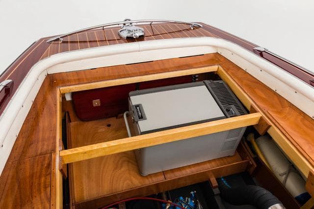 Interior view of a 1995 Boesch 620 Cabrio de Luxe boat, showcasing wooden storage compartment.