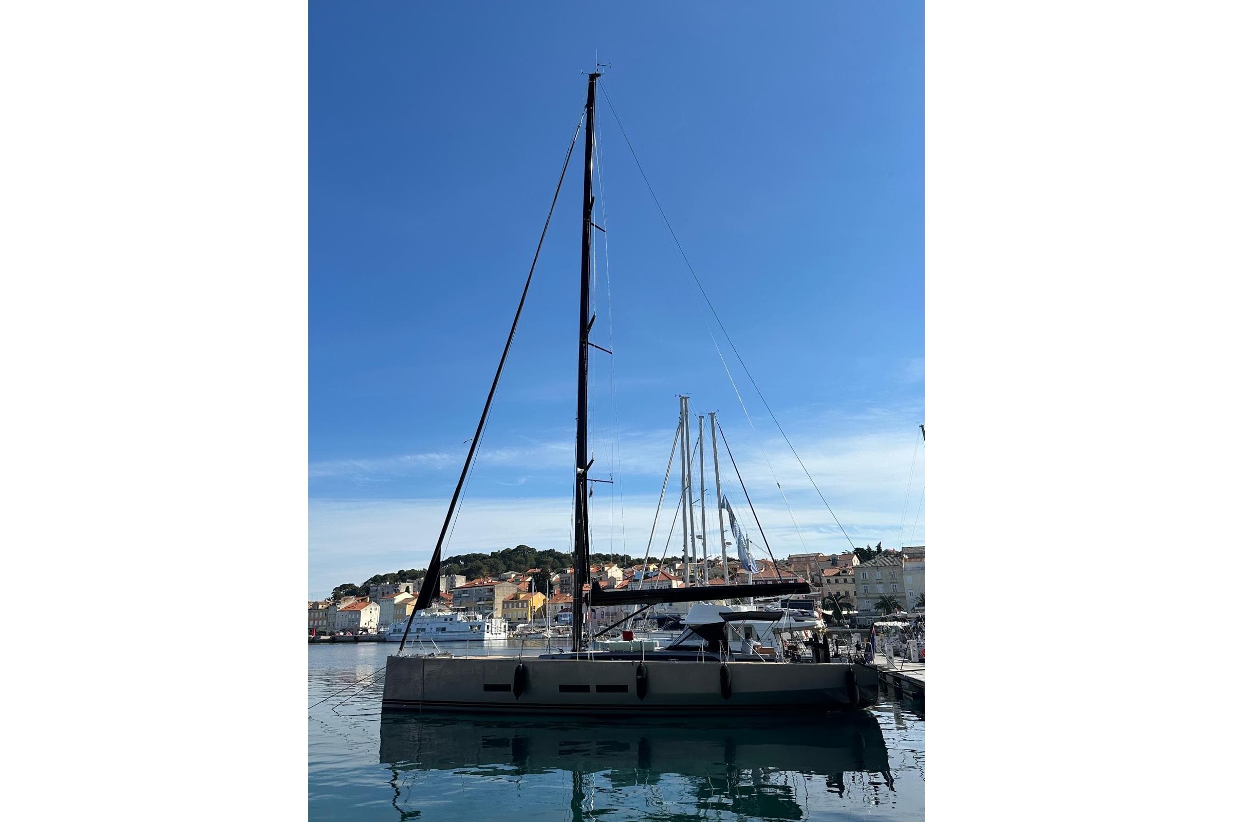 2023 Solaris 55 yacht docked in a scenic harbor under a clear blue sky.